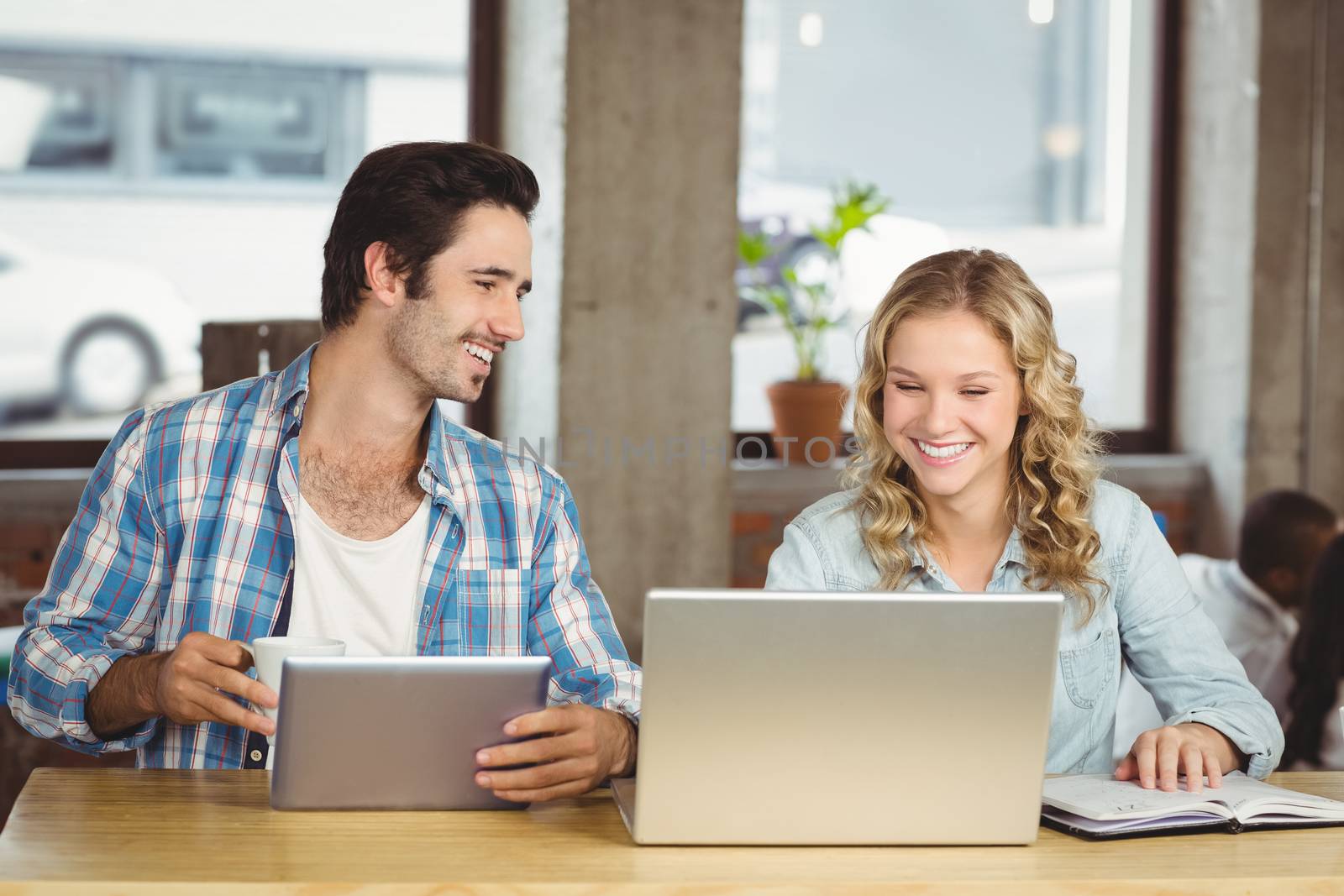Young people smiling and discussing while working at office 