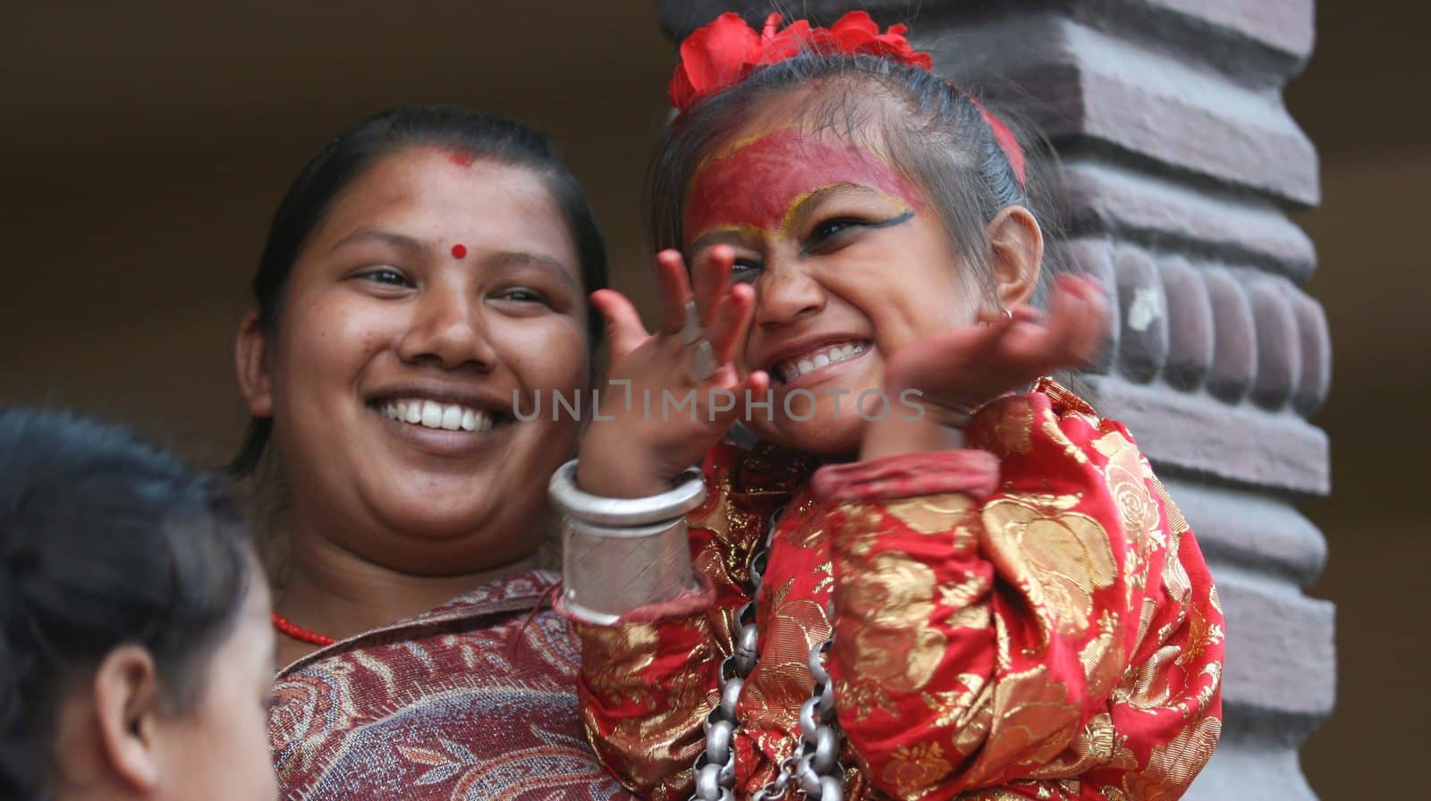 NEPAL, Patan: A Nepalese girl waves during the festival of rain god Rato Machindranath in Patan, Nepal on September 22, 2015. The festival takes place each April, but was delayed this year after a devastating earthquake damaged the chariot that devotees pull through the area in the hope of securing a good harvest.