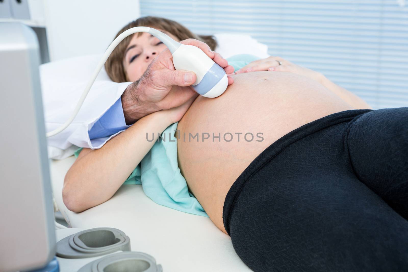 Midsection of male doctor doing ultrasound test in clinic