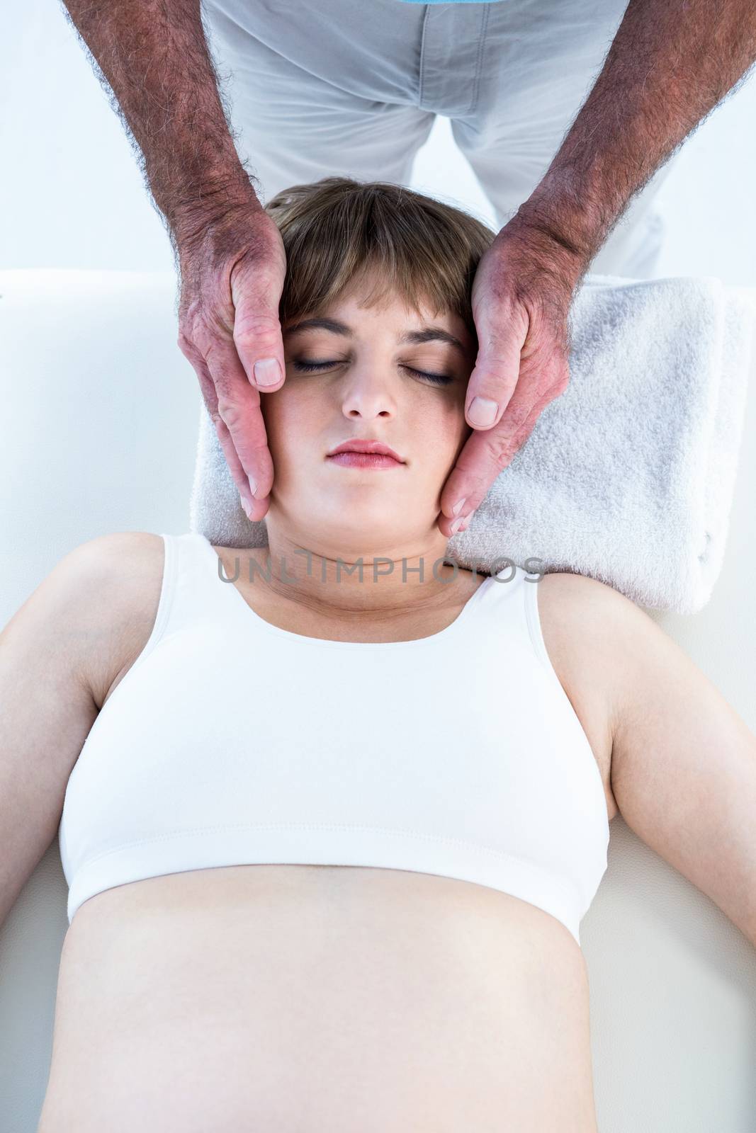 High angle view of calm woman receiving reiki treatment at health club