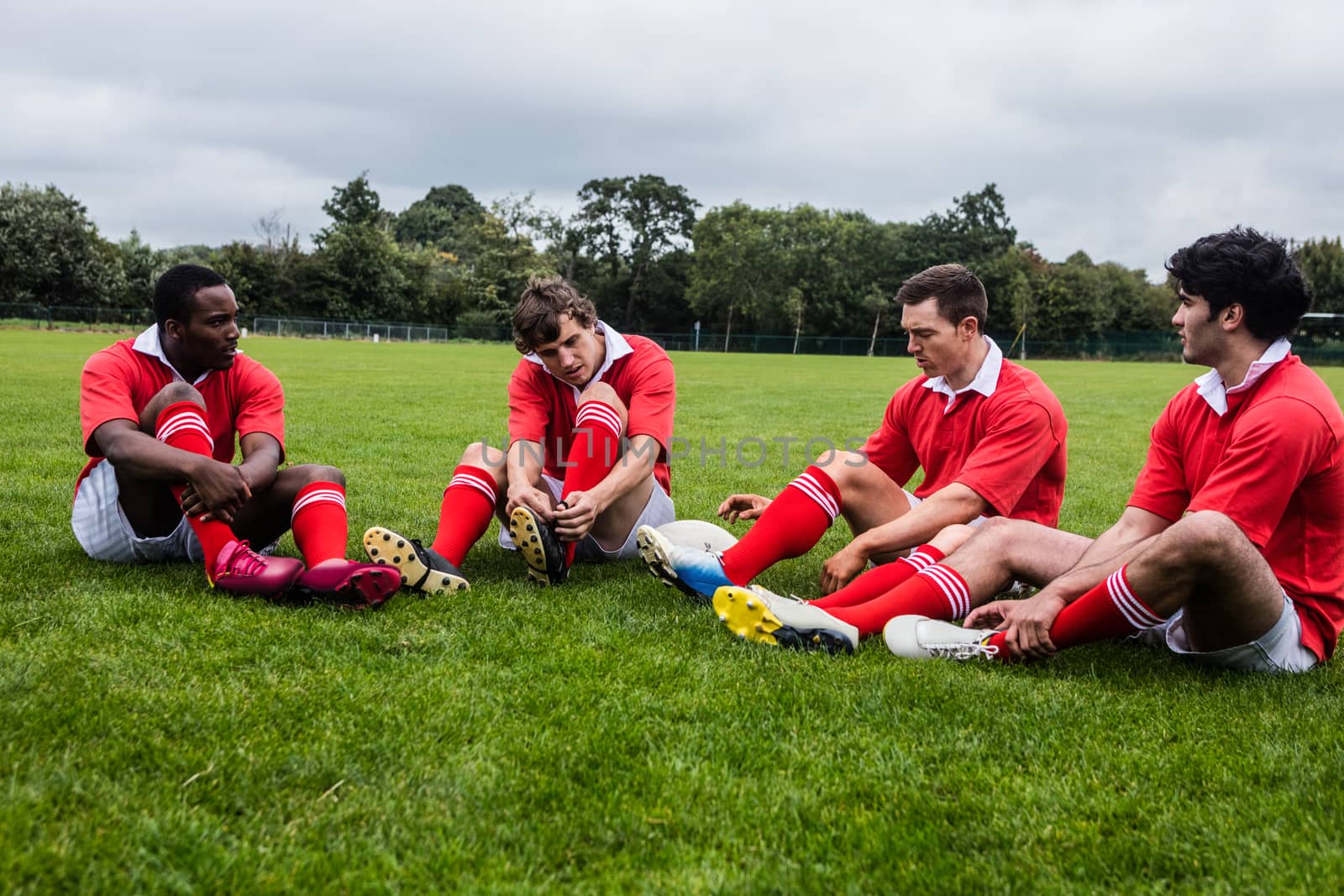 Rugby players sitting on grass before match by Wavebreakmedia