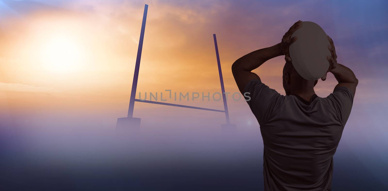 Composite image of rear view of sportsman throwing rugby ball by Wavebreakmedia
