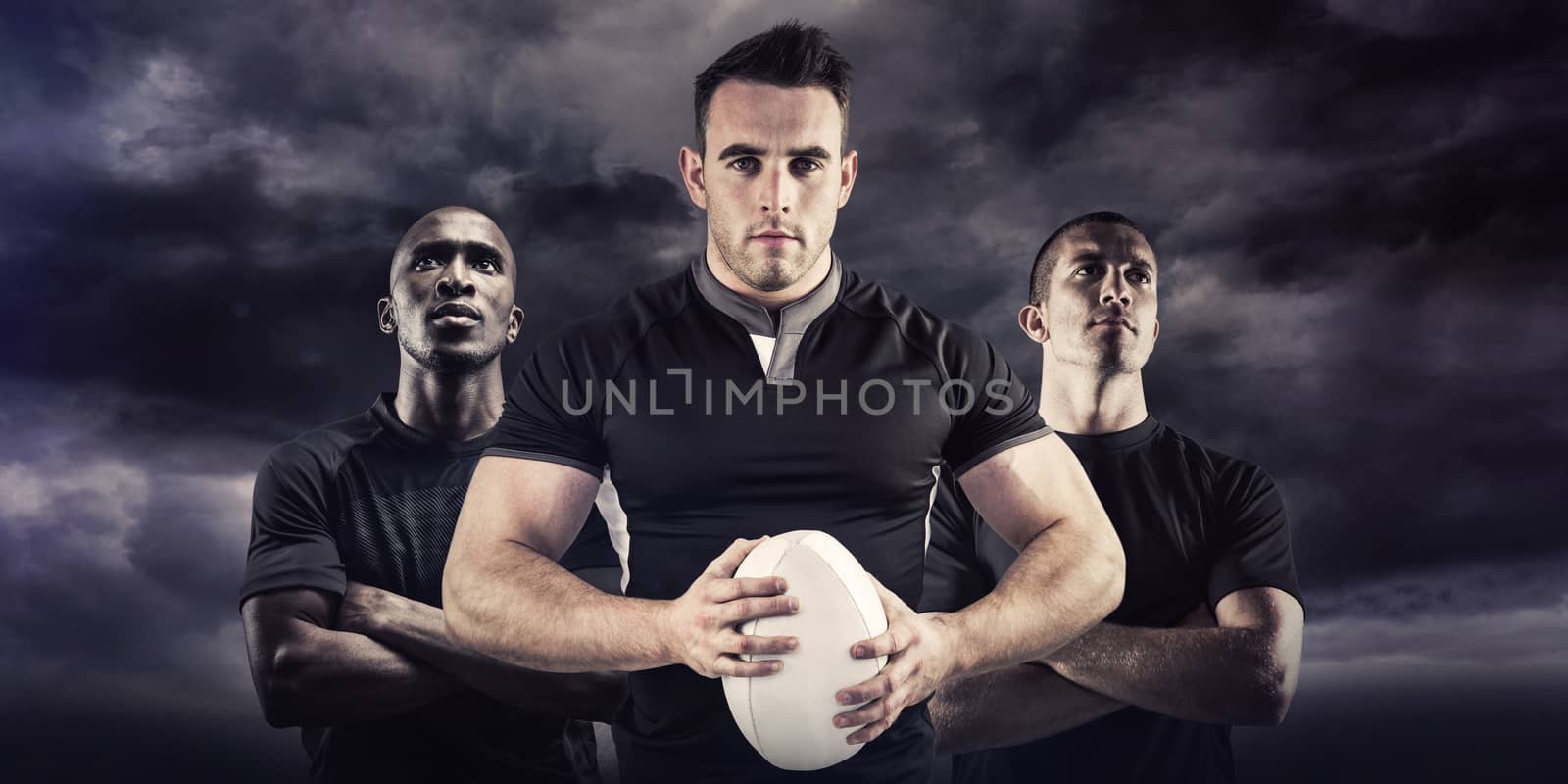 Tough rugby player looking at camera against blue sky