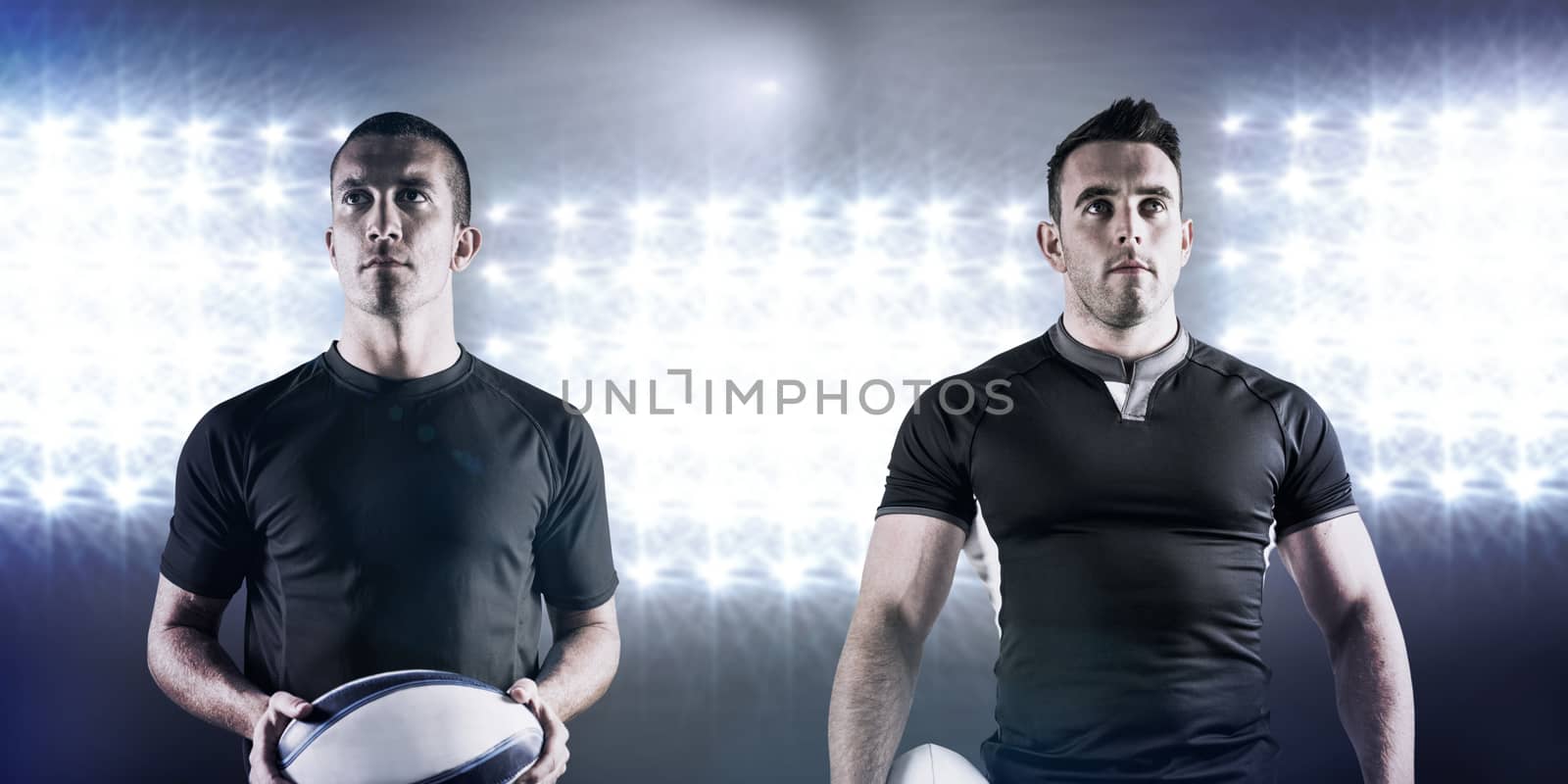 Tough rugby player holding ball against spotlight