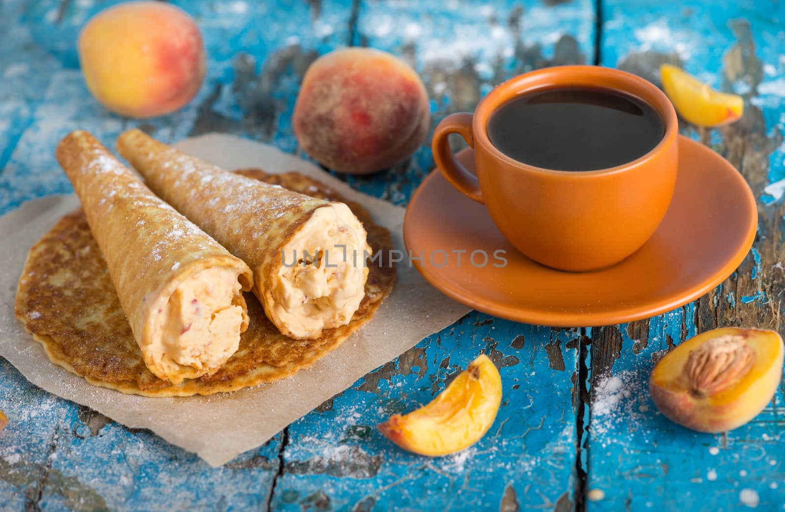 Good morning, Have a nice day. A cup of coffee, delicious waffles with peach ice cream decorated with icing sugar and fresh peaches on old blue vintage wooden background