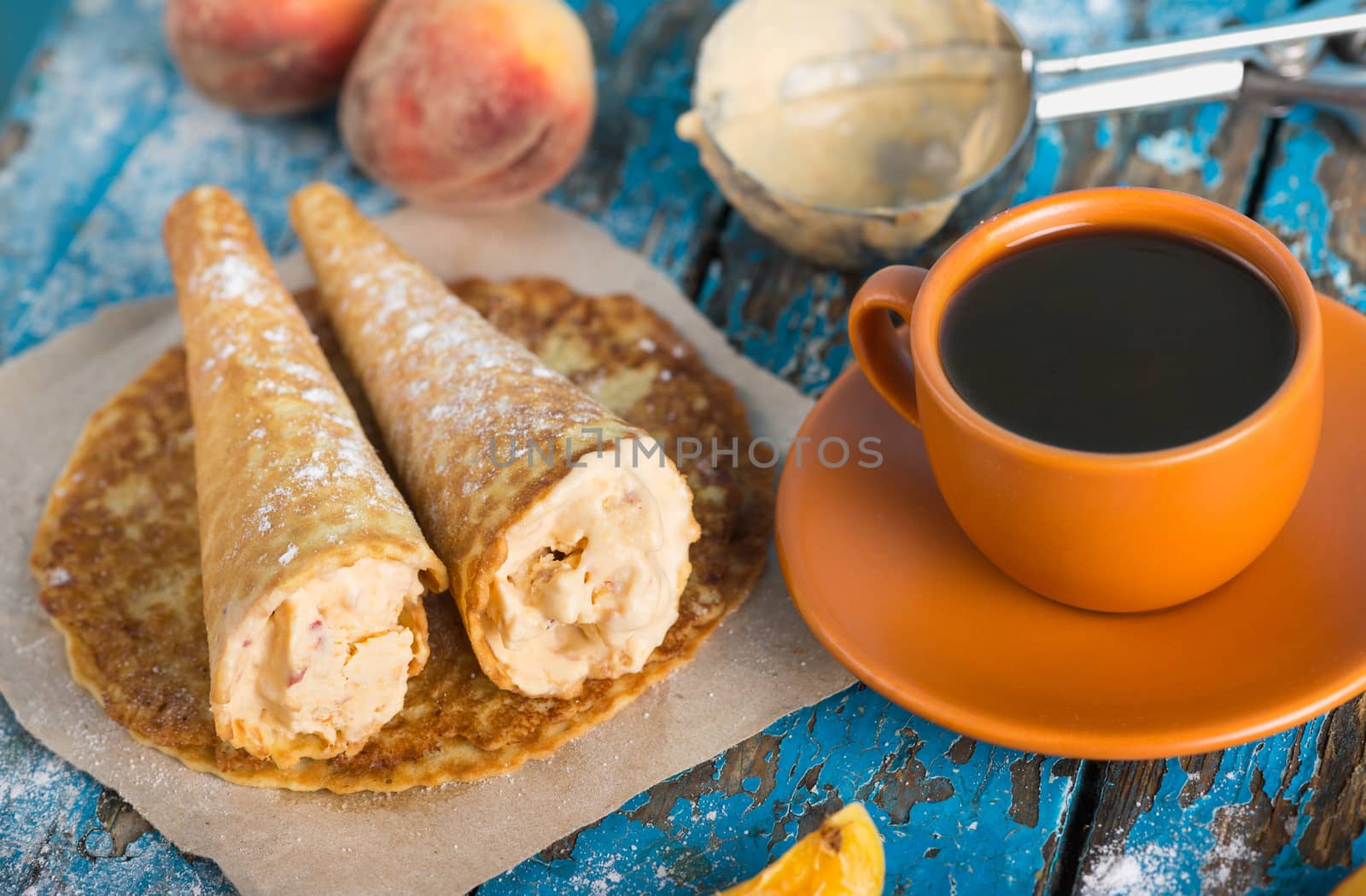 Good morning, Have a nice day. A cup of coffee, delicious waffles with peach ice cream decorated with icing sugar and fresh peaches, spoon for ice cream on old blue vintage wooden background