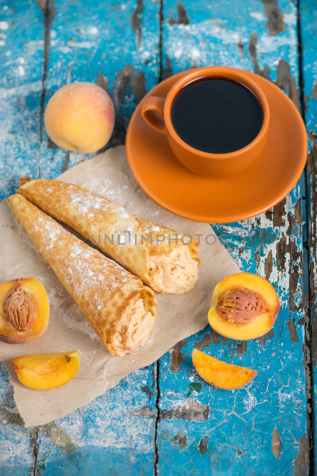 Good morning, Have a nice day. A cup of coffee, delicious waffles with peach ice cream decorated with icing sugar and fresh peaches on old blue vintage wooden background, vertical
