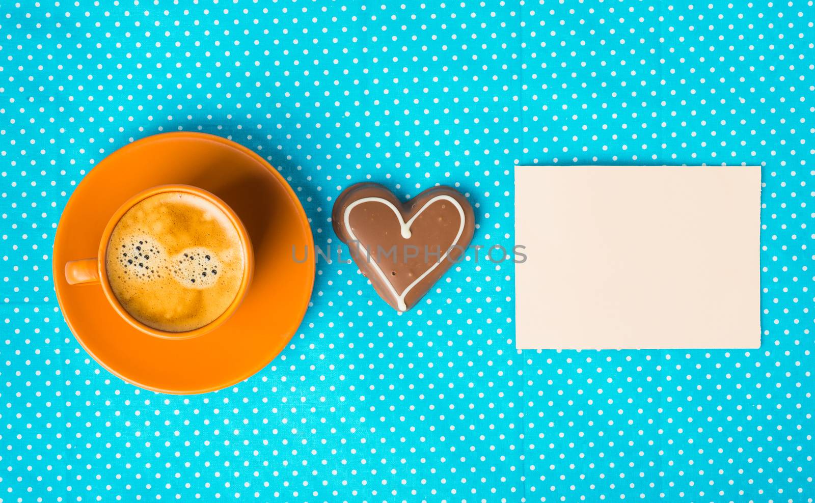 cup with coffee  espresso, tablet for text and chocolate marzipan candy heart on a bright blue background, love concept, have a nice day, good morning, good day, happy Valentine's Day, top view