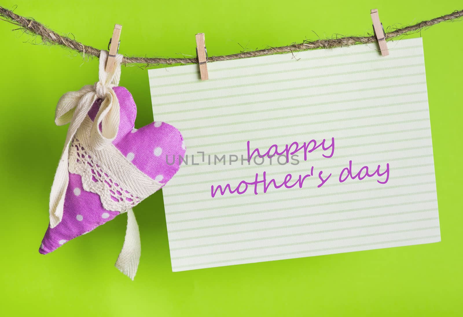 Mothers day message card with the inscription Happy Mother's Day and handmade heart of the cloth with polka dots on a rope with clothespins, greeting concept 