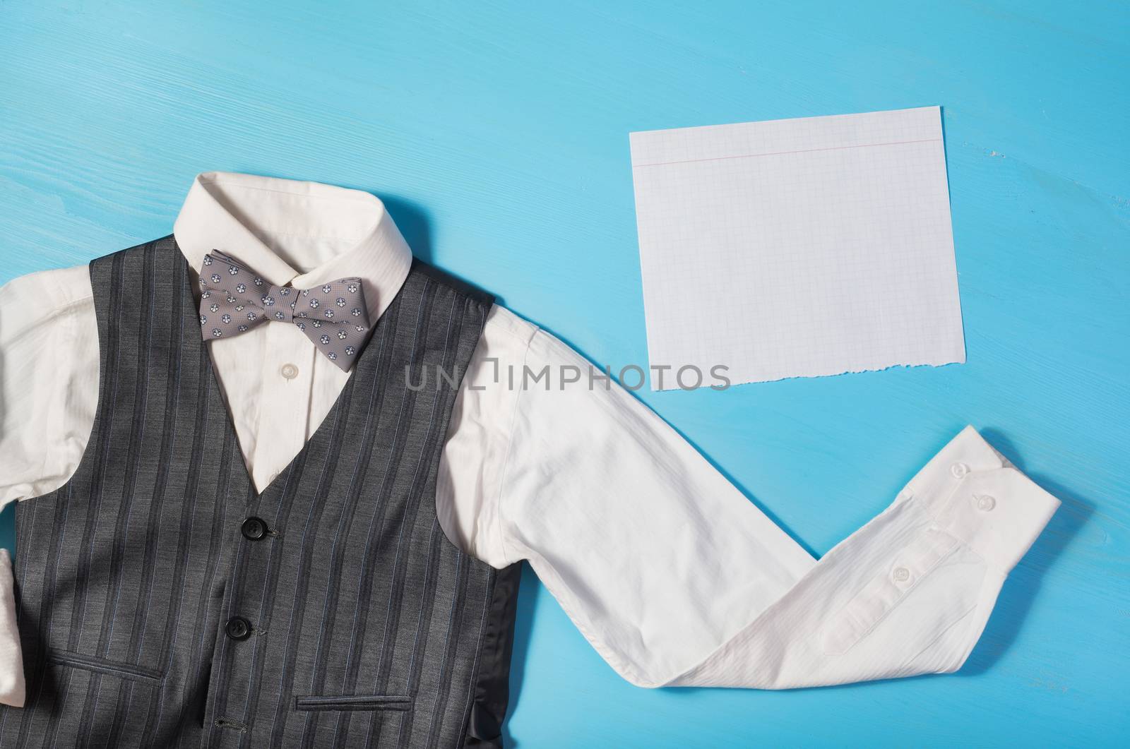 white shirt, gray vest, bow tie and a sheet of paper for text  on a bright blue background, the concept of the festival, celebrations, ceremonies happy Father's Day, Happy Birthday Dad 