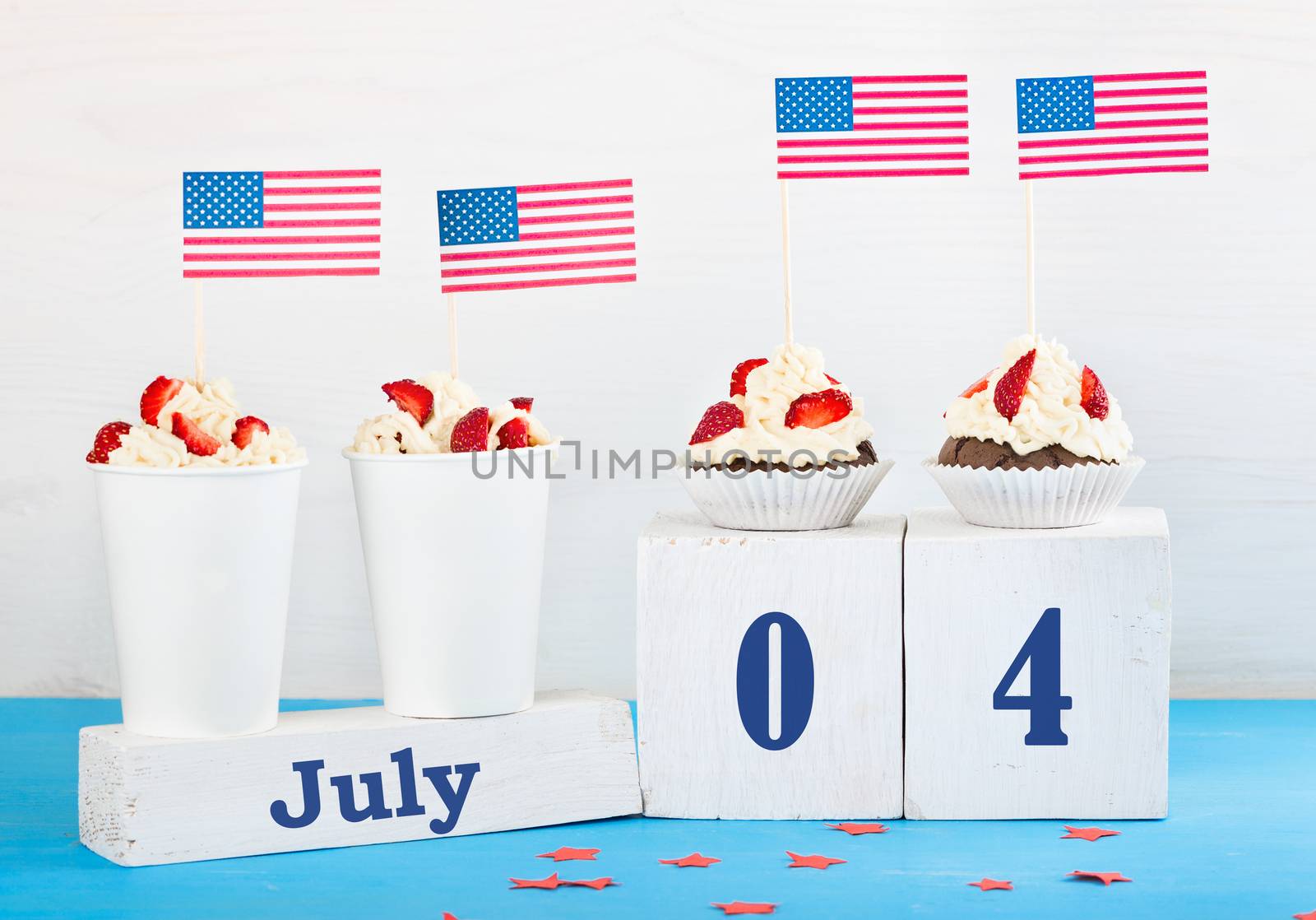 greeting card on the Independence Day of America, two cupcakes, two desserts with cream, strawberries, perpetual calendar with the words Jule 4 on a white and blue background