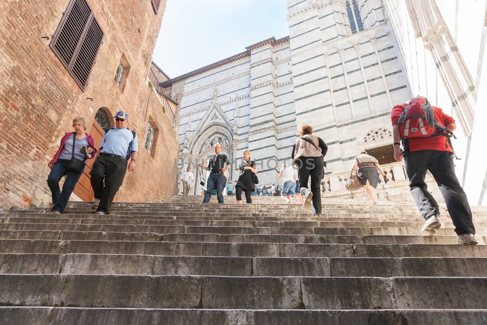 Tourists on steps to Cathedral of Saint Mary of the Assumption in Siena, Italy