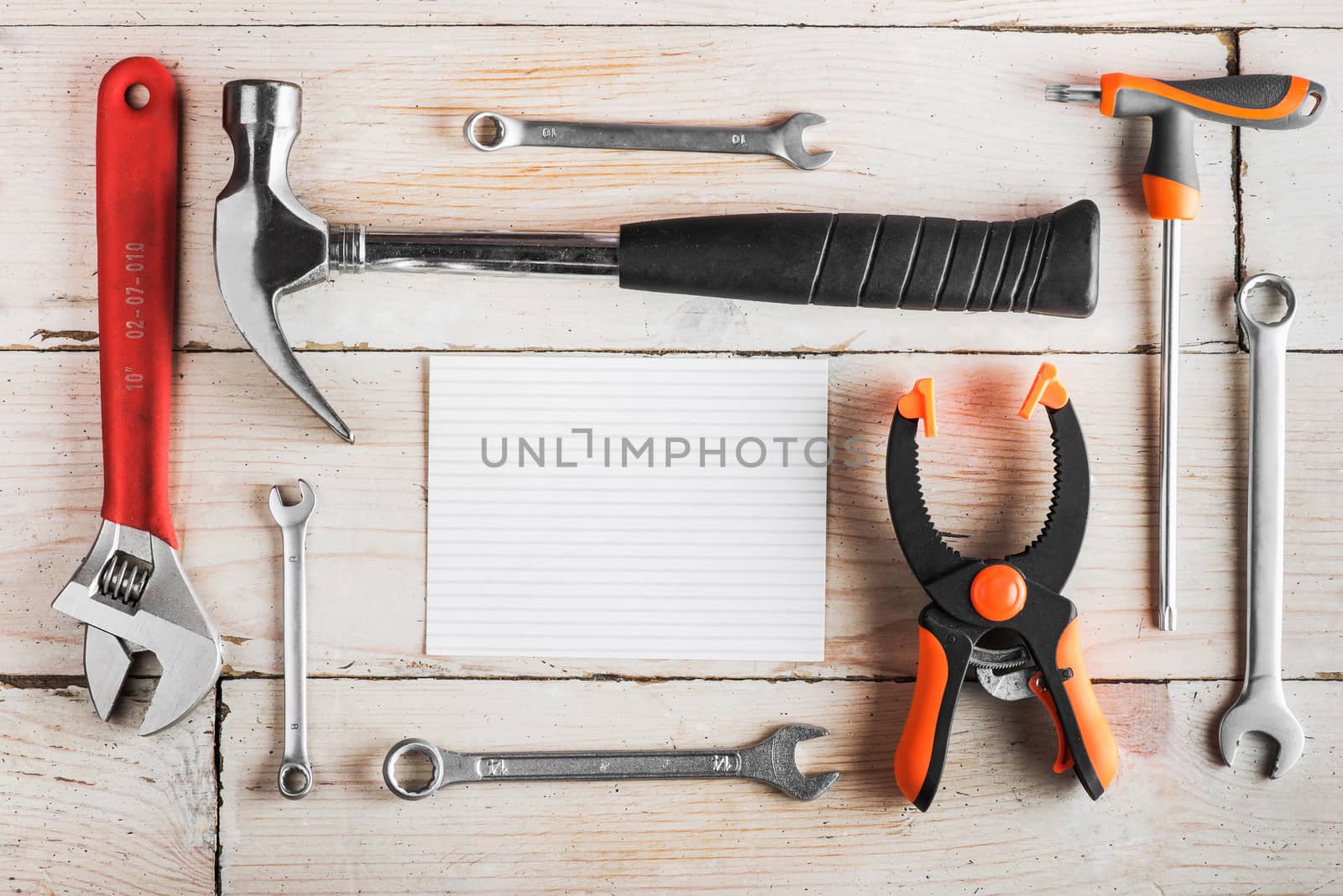 Greeting Card to Happy Father's Day, concept, set of different tools: a hammer, wrench, screwdriver, various spanners, clamp on a wooden background and tablet for an inscription, text, closeup