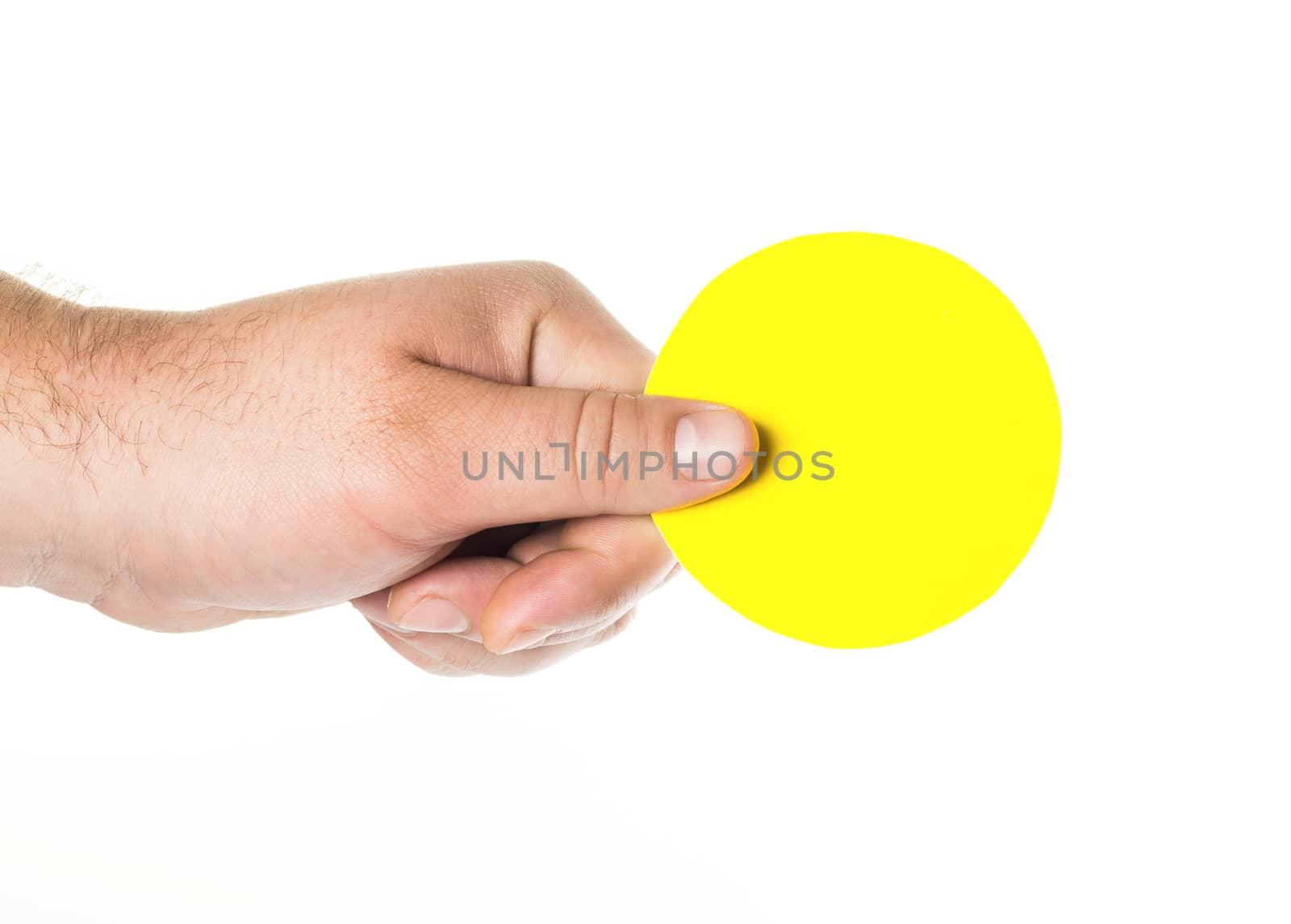 man's hand holding a round yellow tablet, plate for text or inscriptions