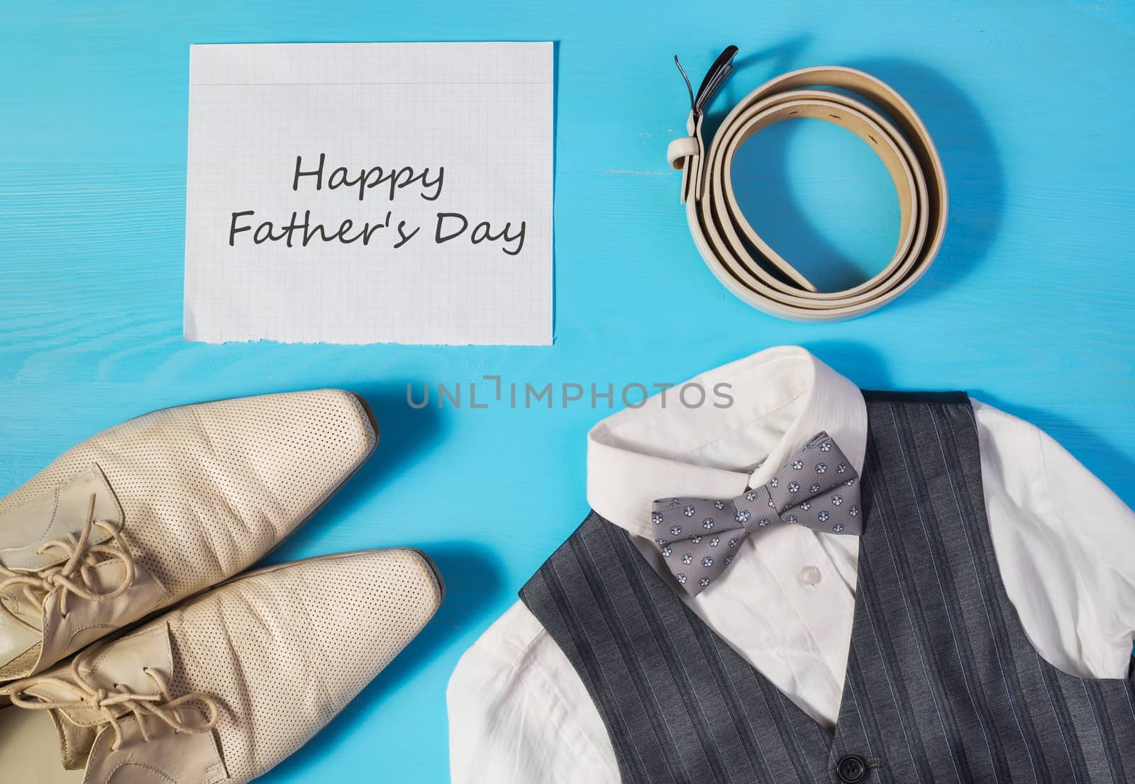 Greeting card for Dad's Day, a white shirt,  men's shoes, gray vest and bow tie, a belt and a sheet of paper with text  Happy Father's Day, concept