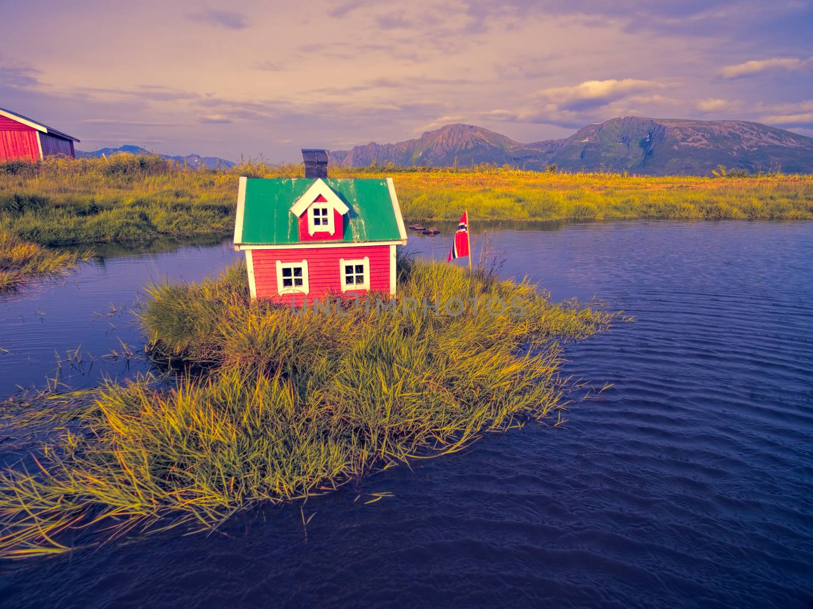 Romantic miniature scandinavian red house on tiny islet