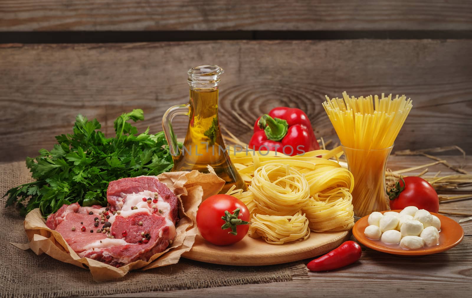 Ingredients for cooking pasta, Italian food, meat and spices, tomato, bell pepper,  olive oil and parsley