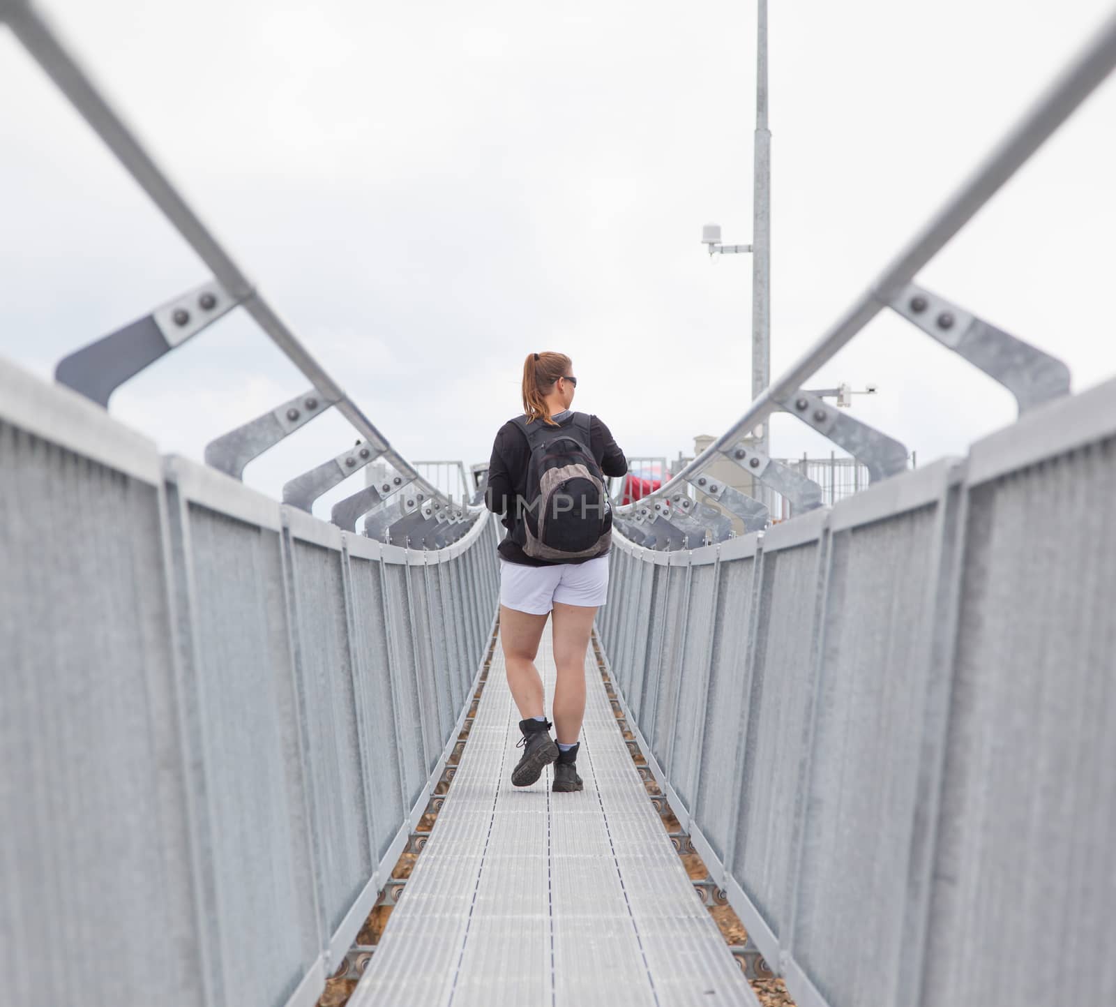 Hiker, young woman with backpack walking on footpath, Switzerland