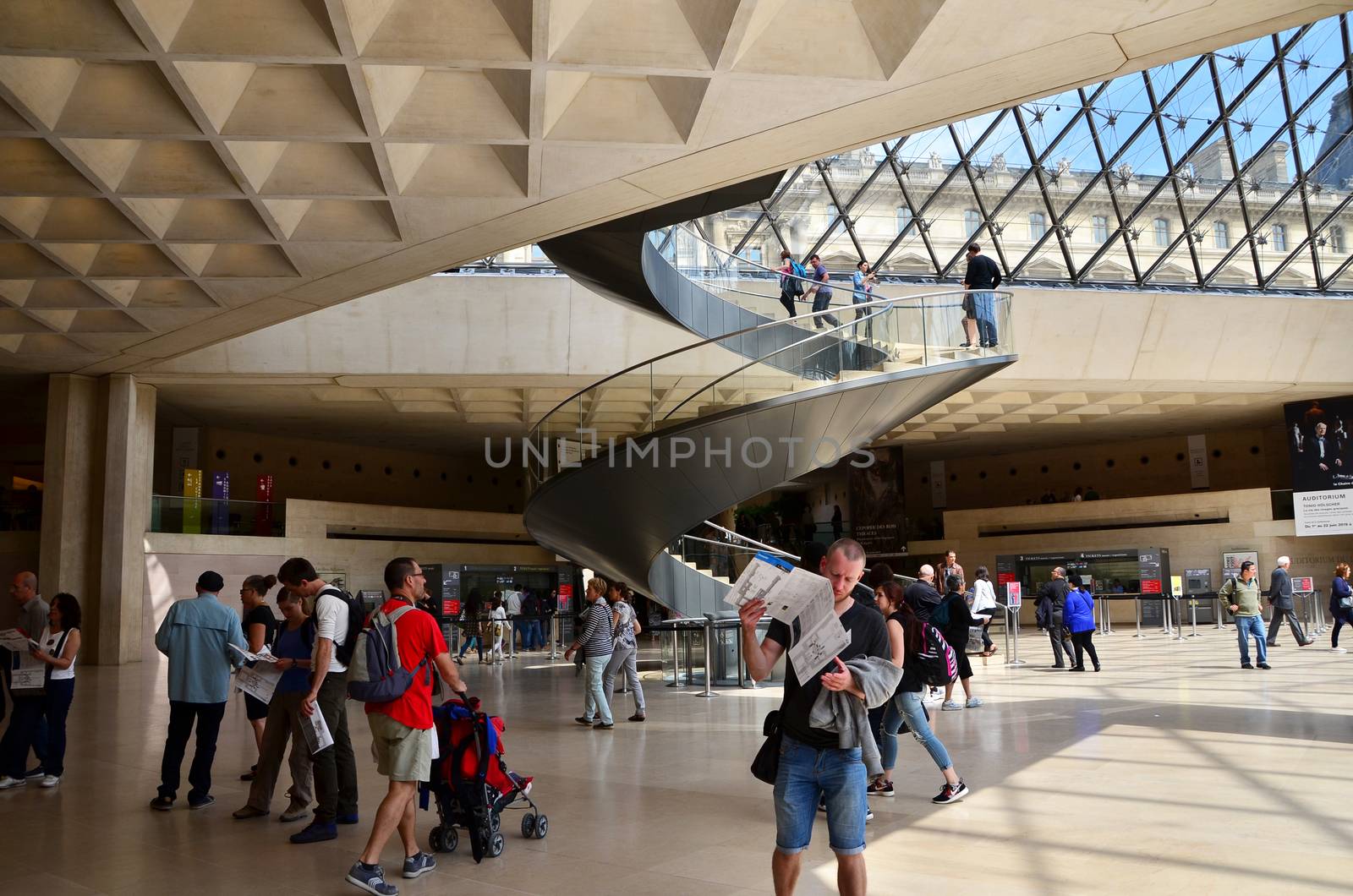 Paris, France - May 13, 2015: Tourists visit Interior of Louvre museum on May 13, 2015 in Paris. Louvre is one of the biggest Museum in the world, receiving more than 8 million visitors each year. 