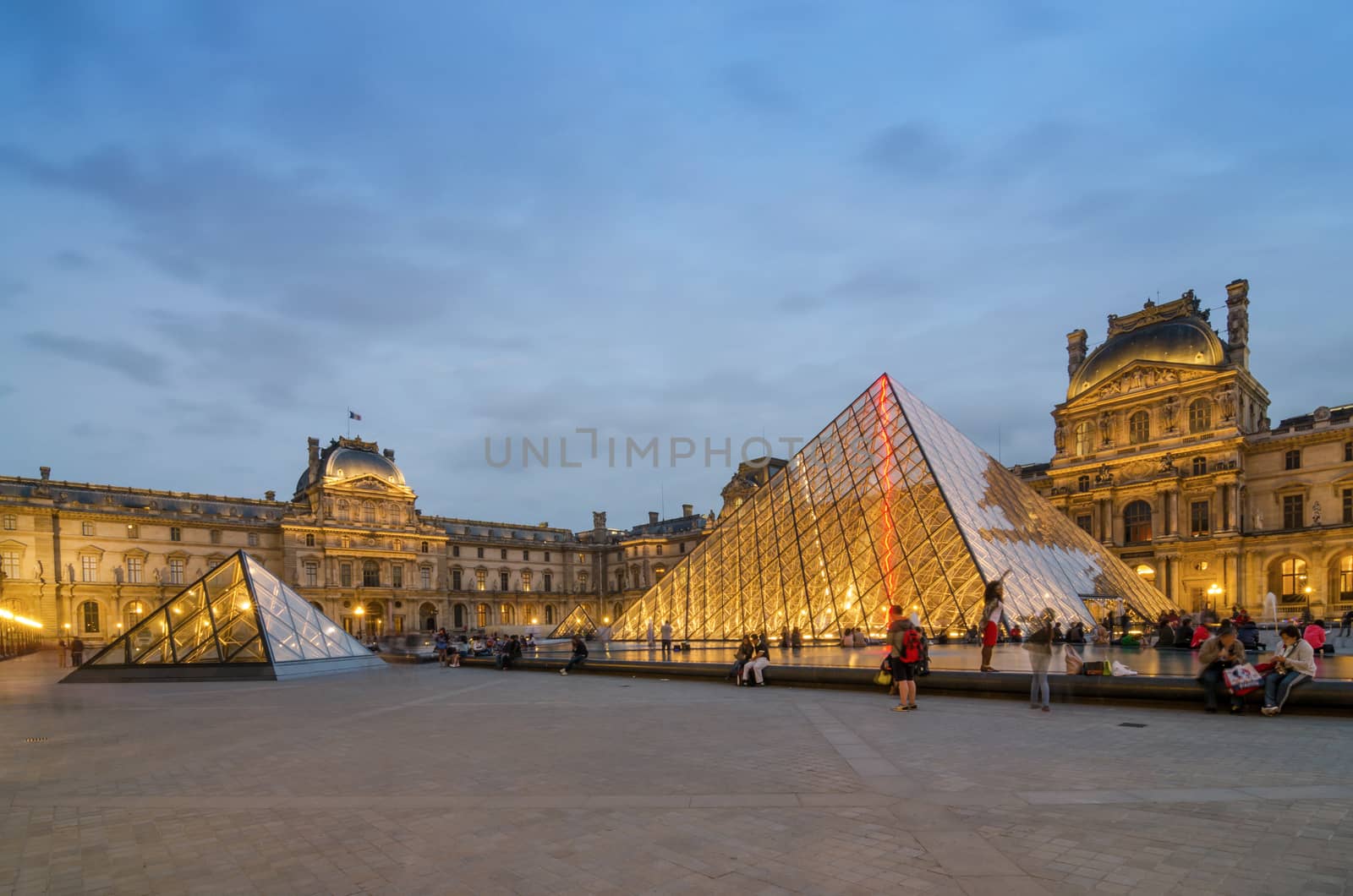 Paris, France - May 14, 2015: Tourists visiting Louvre museum at dusk on May 14, 2015 in Paris. This is one of the most popular tourist destinations in France.