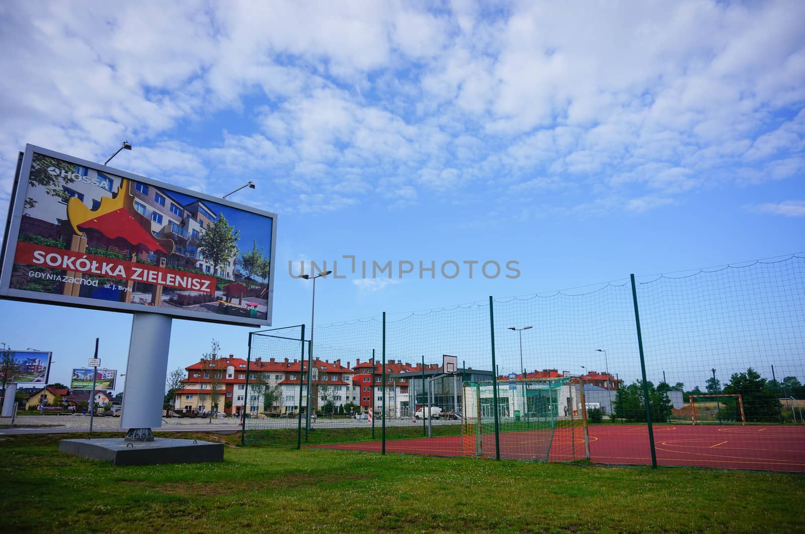 GDYNIA, POLAND - JULY 29, 2015: Commercial billboard next to a sport field by apartment buildings