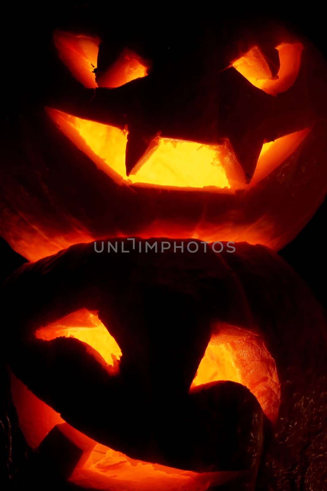 Illuminated cute halloween pumpkins isolated on black background