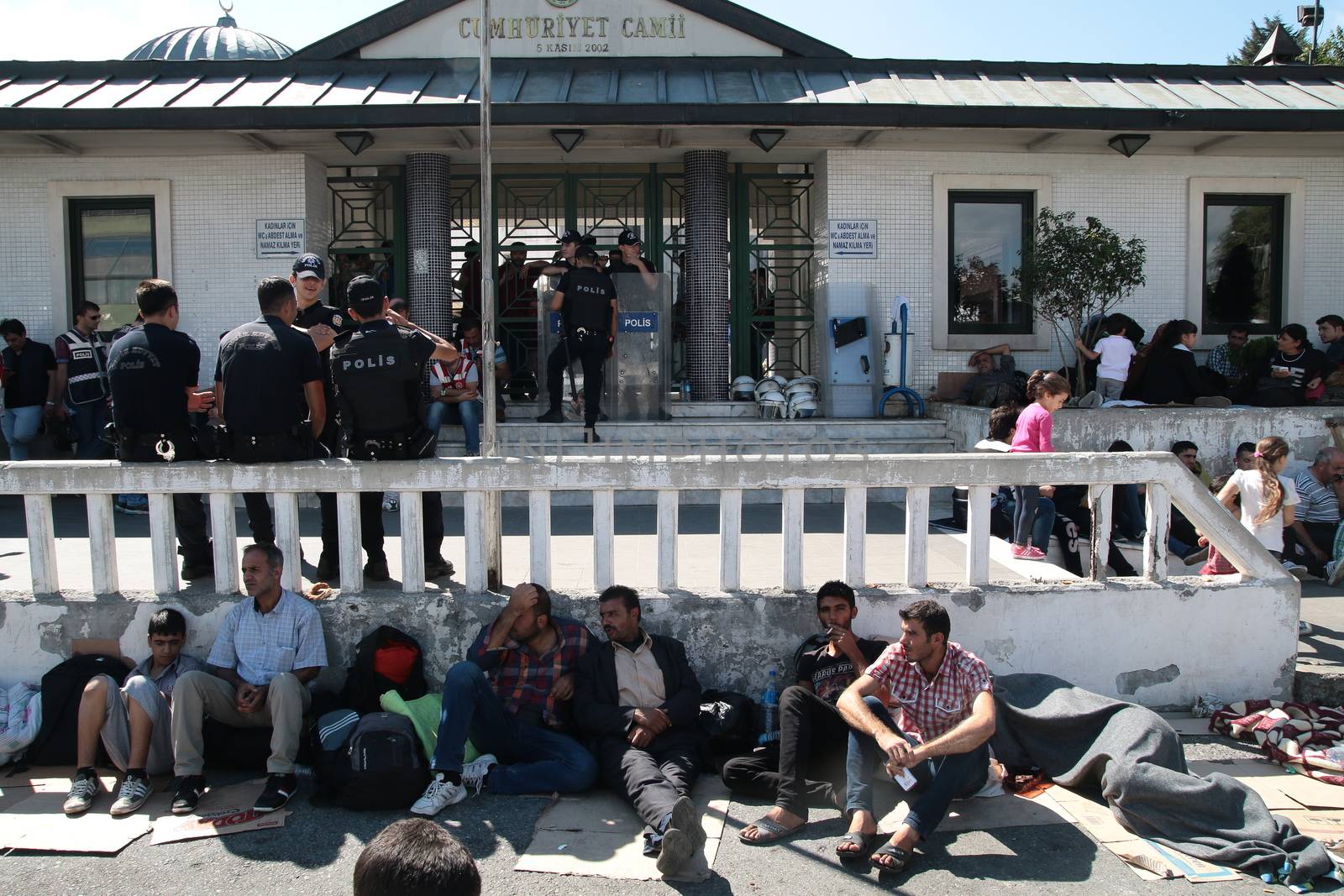 TURKEY, Istanbul: Refugees sit and wait near the Esenler Bus Terminal in Istanbul, Turkey on September 19, 2015 after the government ordered that bus tickets not be sold to them. They are waiting for the government to reverse the decision so they can travel to the Turkish border town of Edirne to continue their journey into Europe