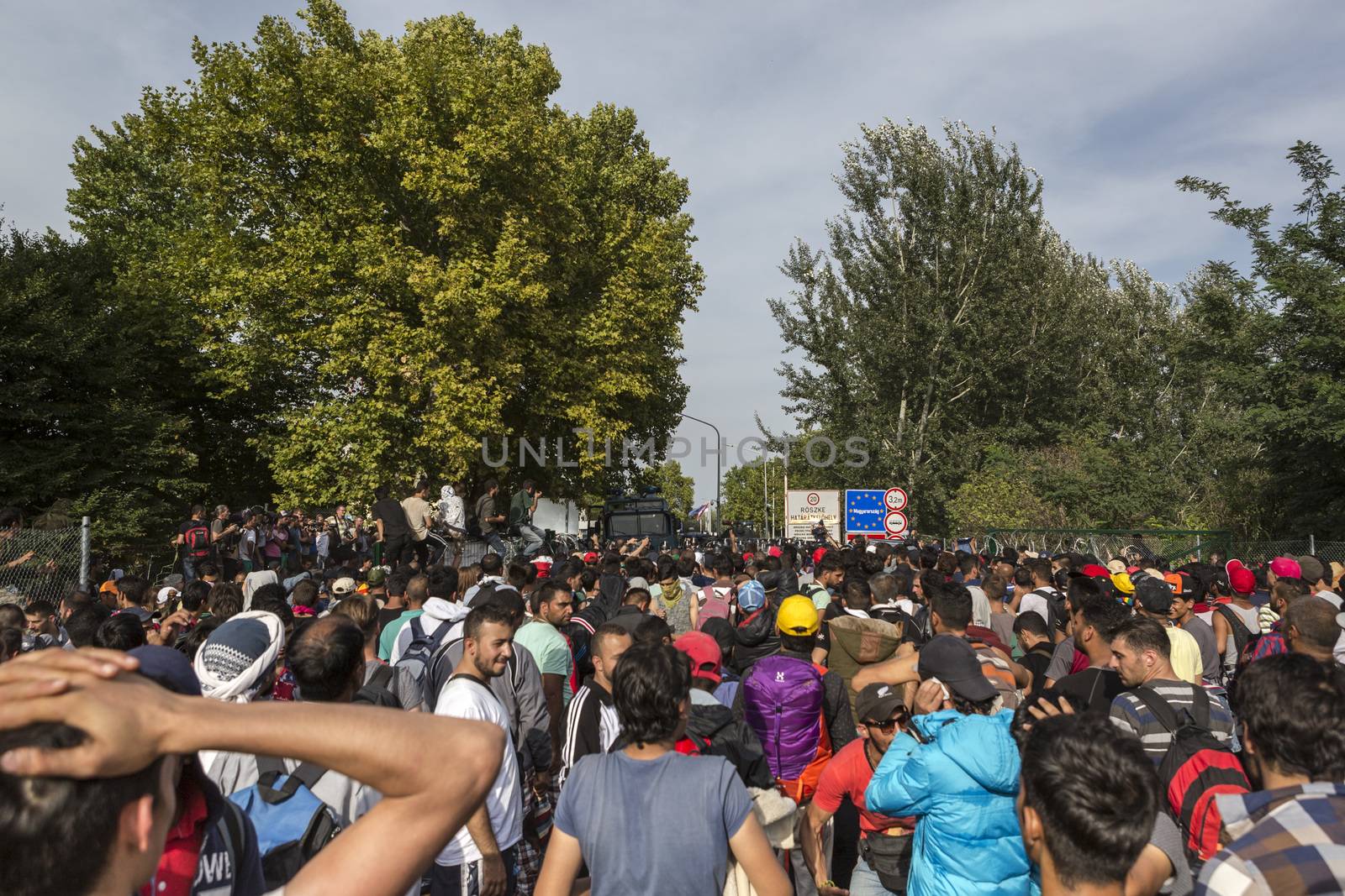 SERBIA, Horgos: Refugees gather at a border fence before Hungarian police fired tear gas and water cannons into the refugees in the Serbian border town of Horgos on September 16, 2015, after Hungary closed its border in an effort to stem the wave of refugees entering the country. 