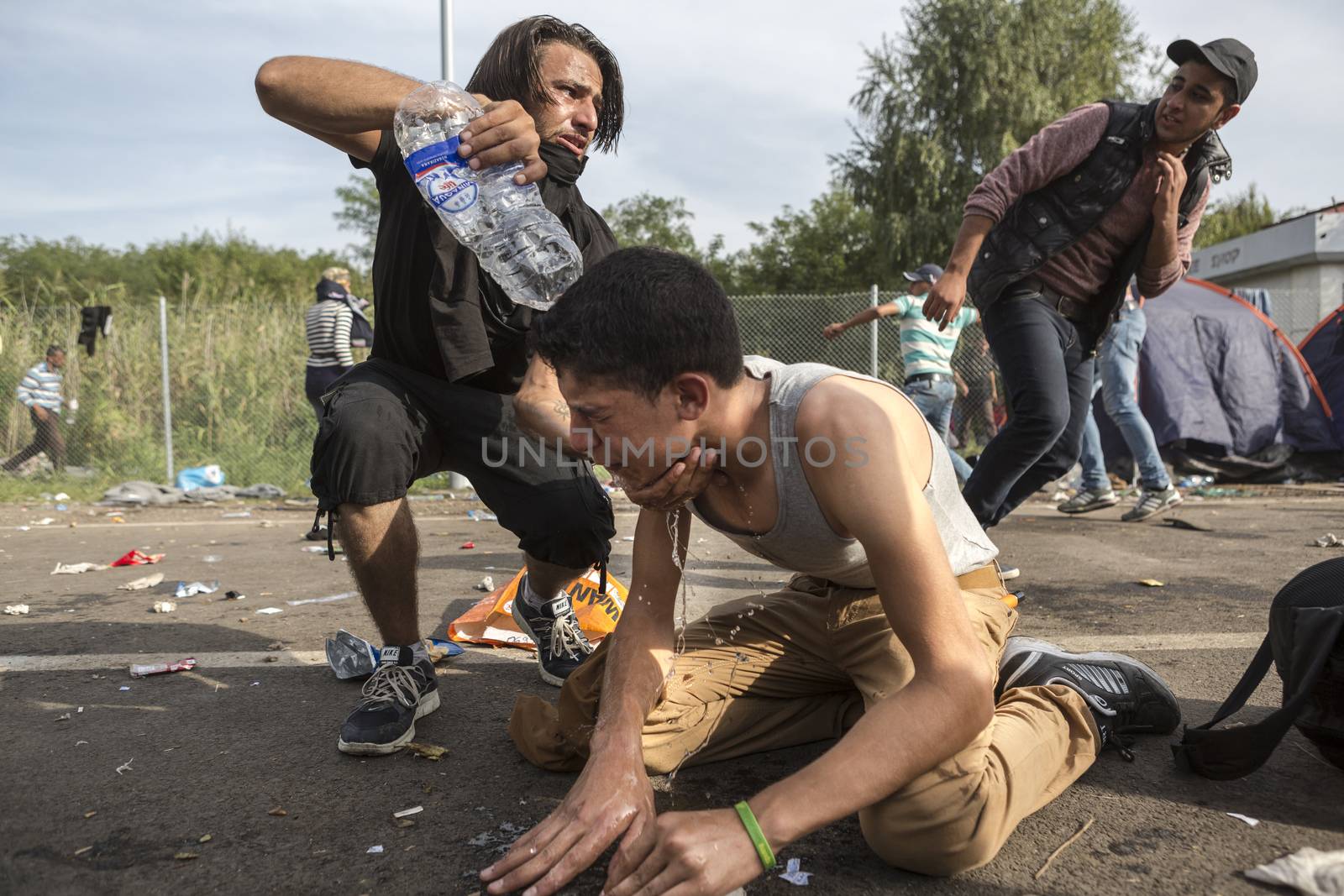 SERBIA, Horgos: A boy is given water after Hungarian police fired tear gas and water cannons into the refugees in the Serbian border town of Horgos on September 16, 2015, after Hungary closed its border in an effort to stem the wave of refugees entering the country. 