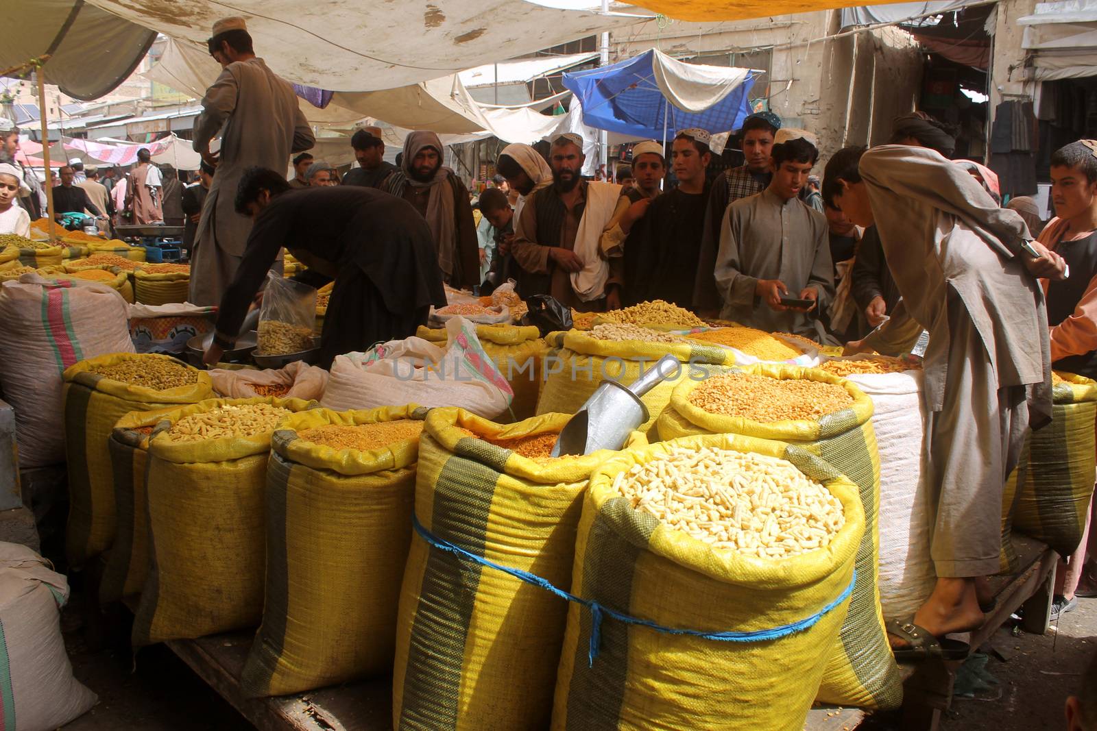 AFGHANISTAN, Kandahar: Crowds are out shopping in Charso Bazaar for Eid on September 22, 2015. Men in traditional dress and women in burqas buy dried fruits, biscuits, clothes, shoes, hats and things for their homes in Charso Bazaar, Kandahar. 