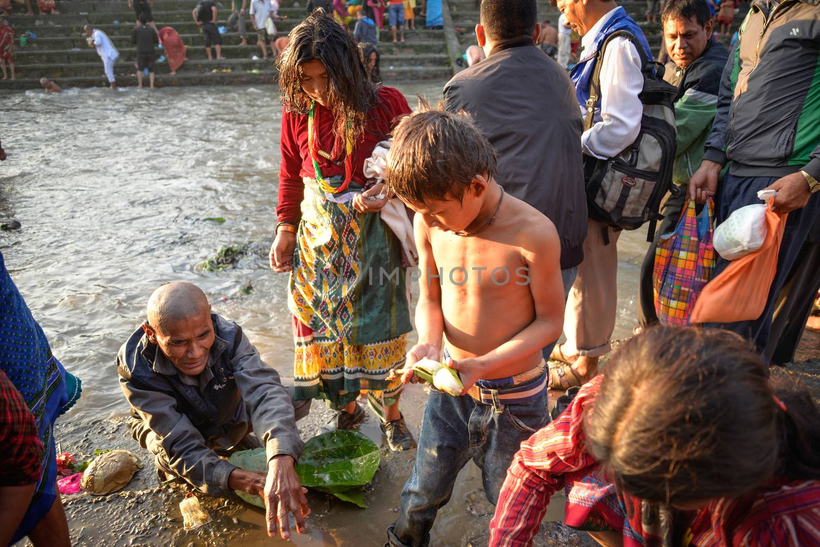 NEPAL, Nuwakot: Santosh Shrestha, a 10 year-old boy from Okharpauwa, Nuwakot District performs a religious ritual at Bagamti River Bank during Father's Day, on September 13, 2015.	Santosh's father passed away when he was six months old, and this was his fifth time performing the religious ritual at Gokarna, along with his grandfather, grandmother and his mother. He lives in poverty on a rubbish dump with his family, and is not able to go to school. 