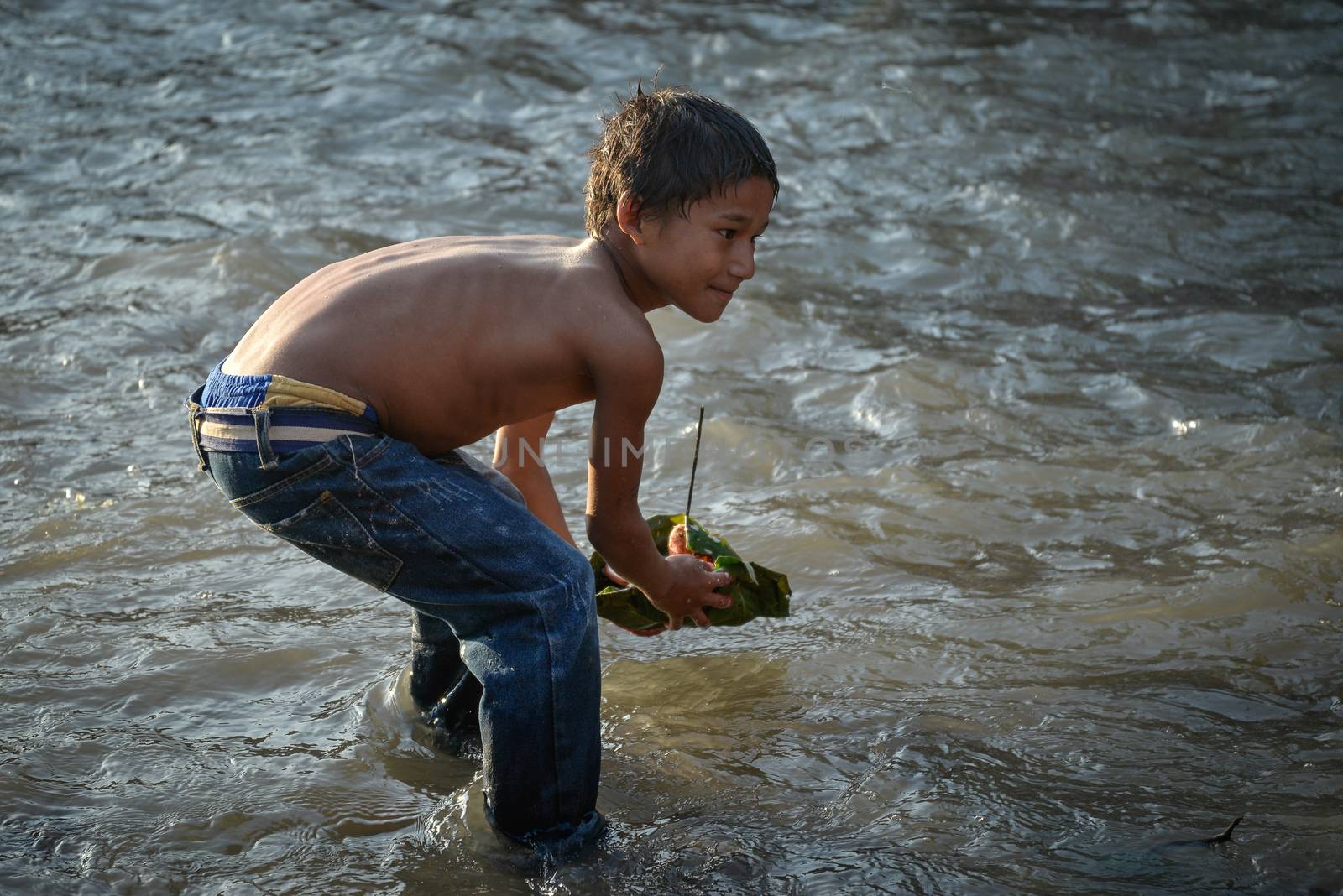 NEPAL, Nuwakot: Santosh Shrestha, a 10 year-old boy from Okharpauwa, Nuwakot District performs a religious ritual at Bagamti River Bank during Father's Day, on September 13, 2015.	Santosh's father passed away when he was six months old, and this was his fifth time performing the religious ritual at Gokarna, along with his grandfather, grandmother and his mother. He lives in poverty on a rubbish dump with his family, and is not able to go to school. 