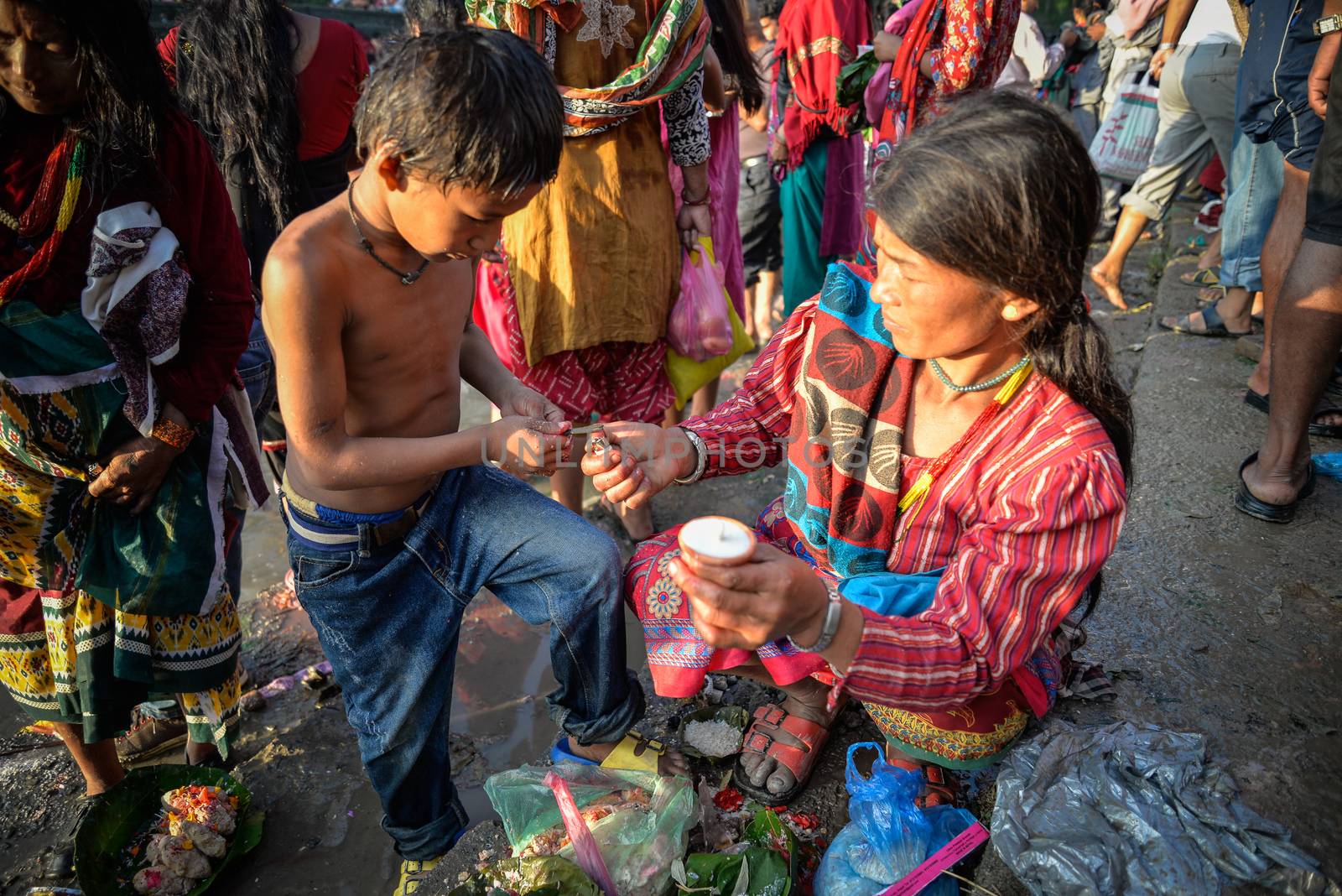 NEPAL, Nuwakot: Santosh Shrestha, a 10 year-old boy from Okharpauwa, Nuwakot District performs a religious ritual at Bagamti River Bank during Father's Day, on September 13, 2015.	Santosh's father passed away when he was six months old, and this was his fifth time performing the religious ritual at Gokarna, along with his grandfather, grandmother and his mother. He lives in poverty on a rubbish dump with his family, and is not able to go to school. 