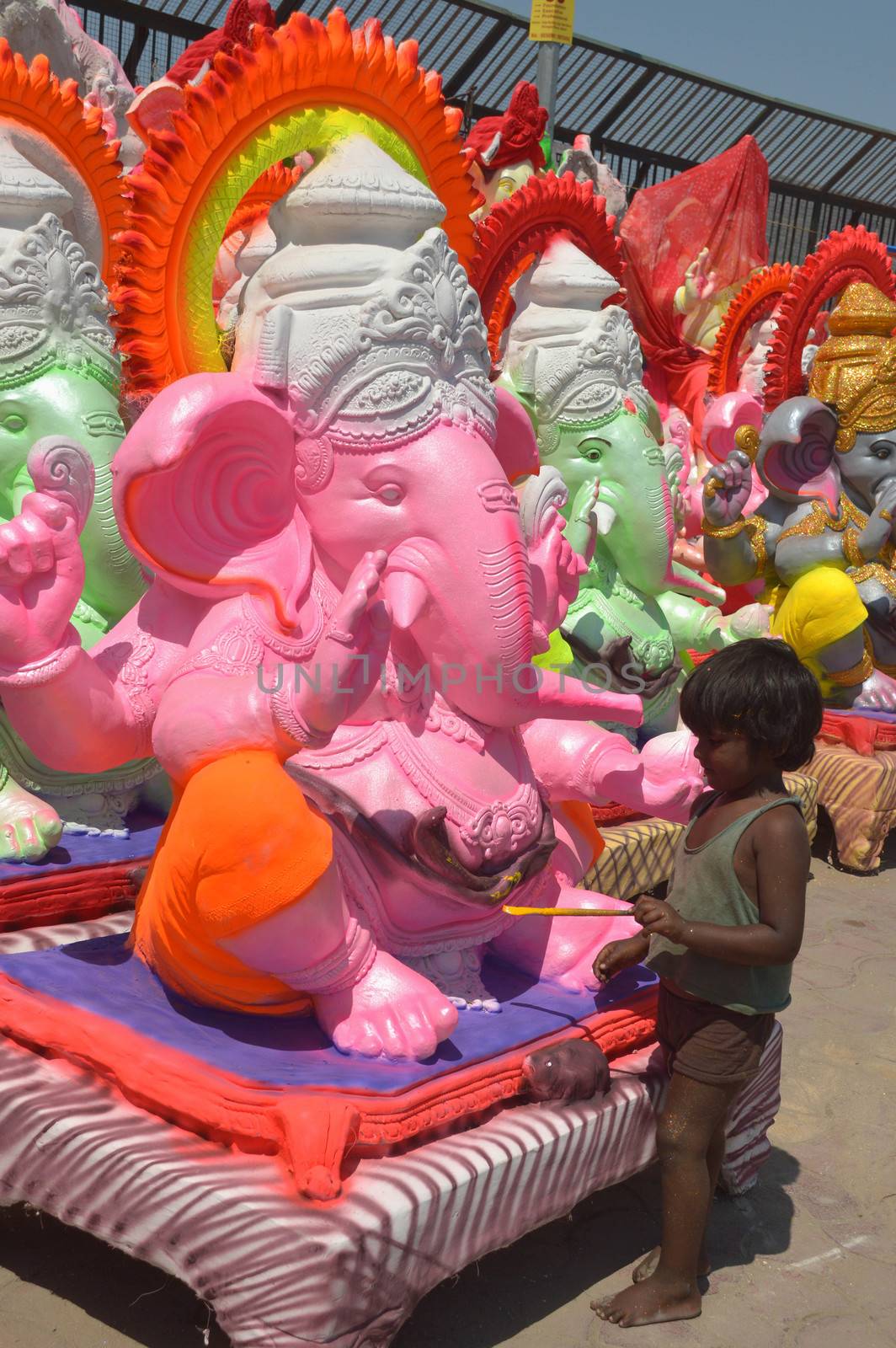 INDIA, Ajmer: An Indian child worker, Shani Bawari (5), puts the finishing touches of colourful paint onto his statues of the Hindu god Lord Ganesh, on September 11, 2015. 	Working on the outskirts of Ajmer, Rajasthan, Shani is preparing the statues for sale ahead of the forthcoming Ganesh Chaturthi festival on 17 September.Arjun Bawari, the boy's father, gave permission for the photos to be taken.