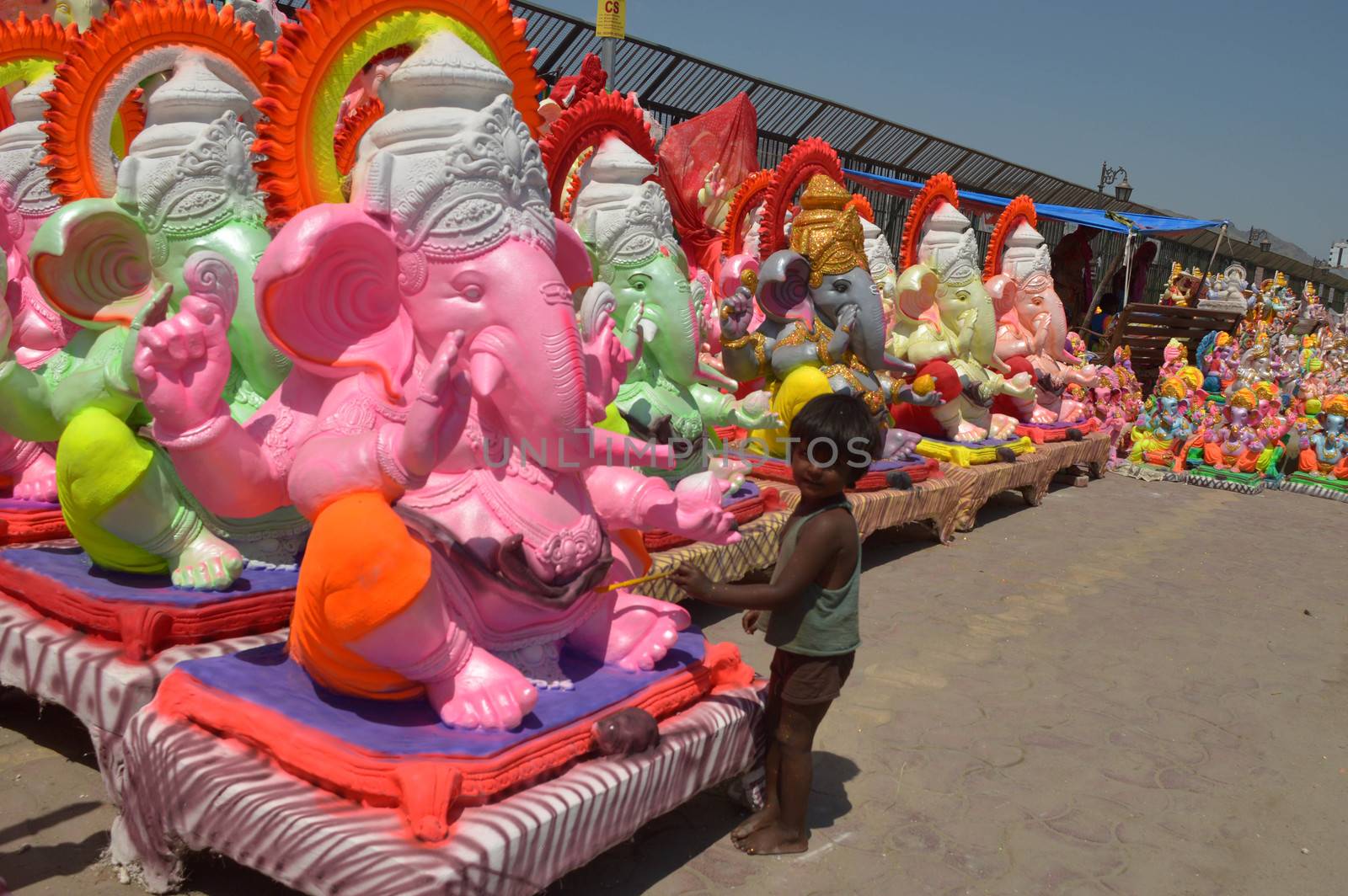 INDIA, Ajmer: An Indian child worker, Shani Bawari (5), puts the finishing touches of colourful paint onto his statues of the Hindu god Lord Ganesh, on September 11, 2015. 	Working on the outskirts of Ajmer, Rajasthan, Shani is preparing the statues for sale ahead of the forthcoming Ganesh Chaturthi festival on 17 September.Arjun Bawari, the boy's father, gave permission for the photos to be taken.