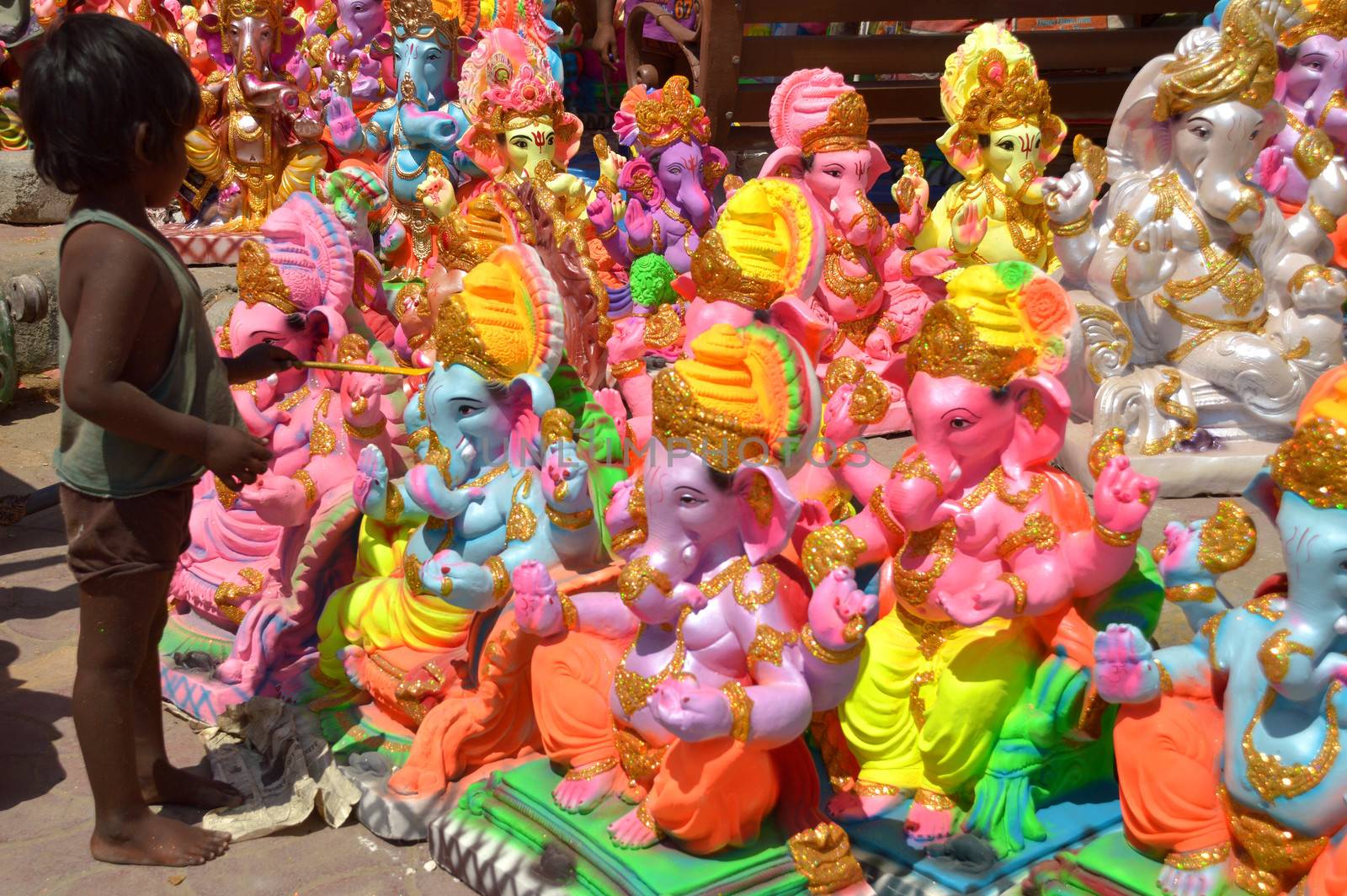 INDIA, Ajmer: An Indian child worker, Shani Bawari (5), puts the finishing touches of colourful paint onto his statues of the Hindu god Lord Ganesh, on September 11, 2015. 	Working on the outskirts of Ajmer, Rajasthan, Shani is preparing the statues for sale ahead of the forthcoming Ganesh Chaturthi festival on 17 September.Arjun Bawari, the boy's father, gave permission for the photos to be taken.