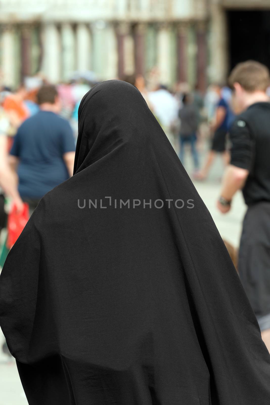 Traditional Muslim woman with black veil view from behind