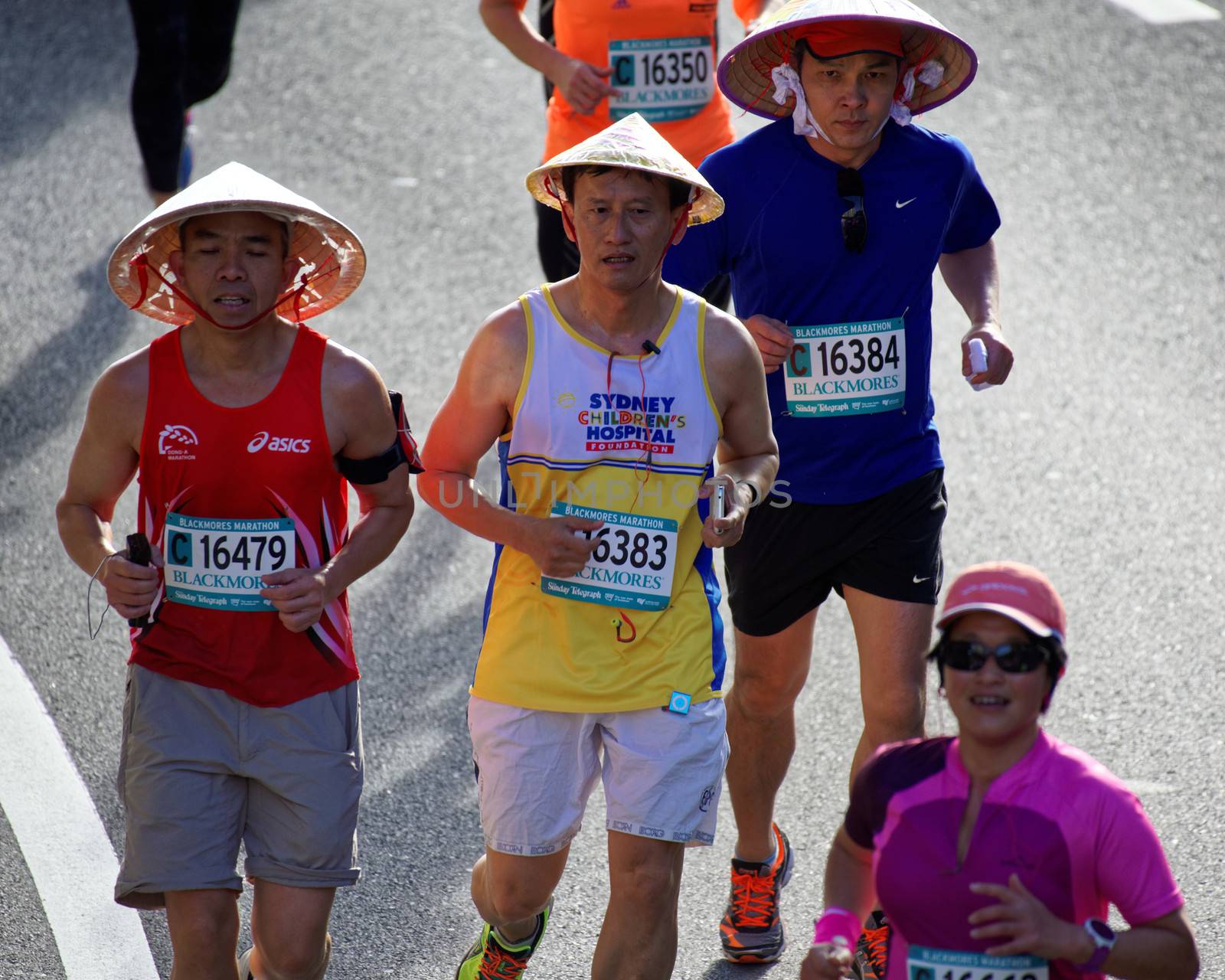 AUSTRALIA, Sydney: Participants wearing Asian conical hats compete in the Sydney Running Festival on September 20, 2015. Around 30,000 participants took part in the 15th Sydney Running Festival which incorporates a 42km marathon, a half marathon, a 9km bridge run as well as a 3.5km family fun run