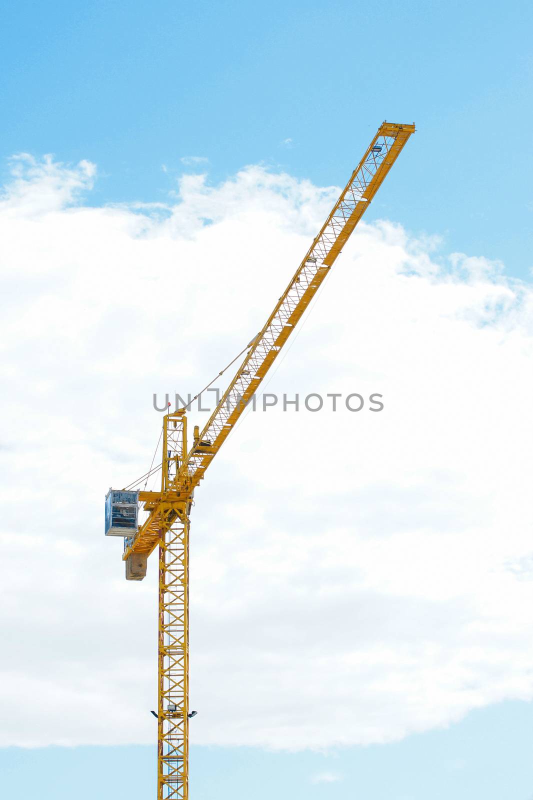 Yellow Industrial crane and blue sky on construction site or sea by mranucha