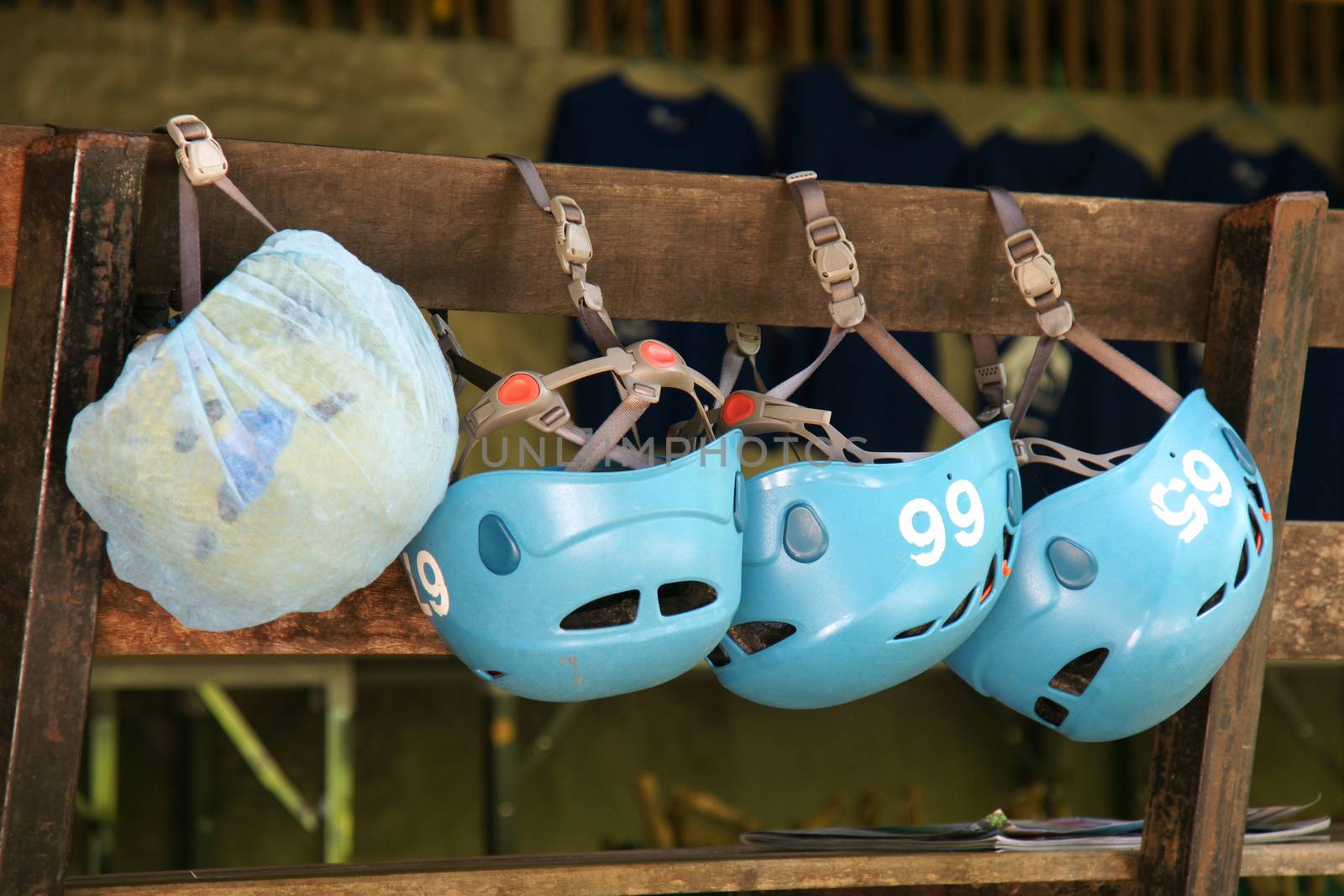 Group of safety helmets for zipline jungle adventure extreme sports hang on the wooden terrace