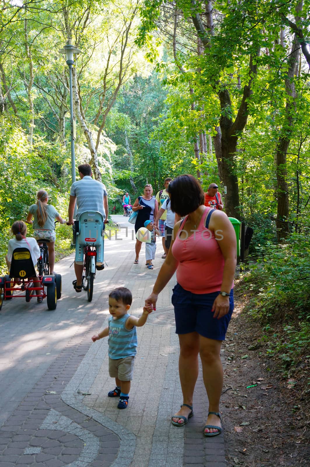 SIANOZETY, POLAND - JULY 22, 2015: Woman and child walking on a park footpath