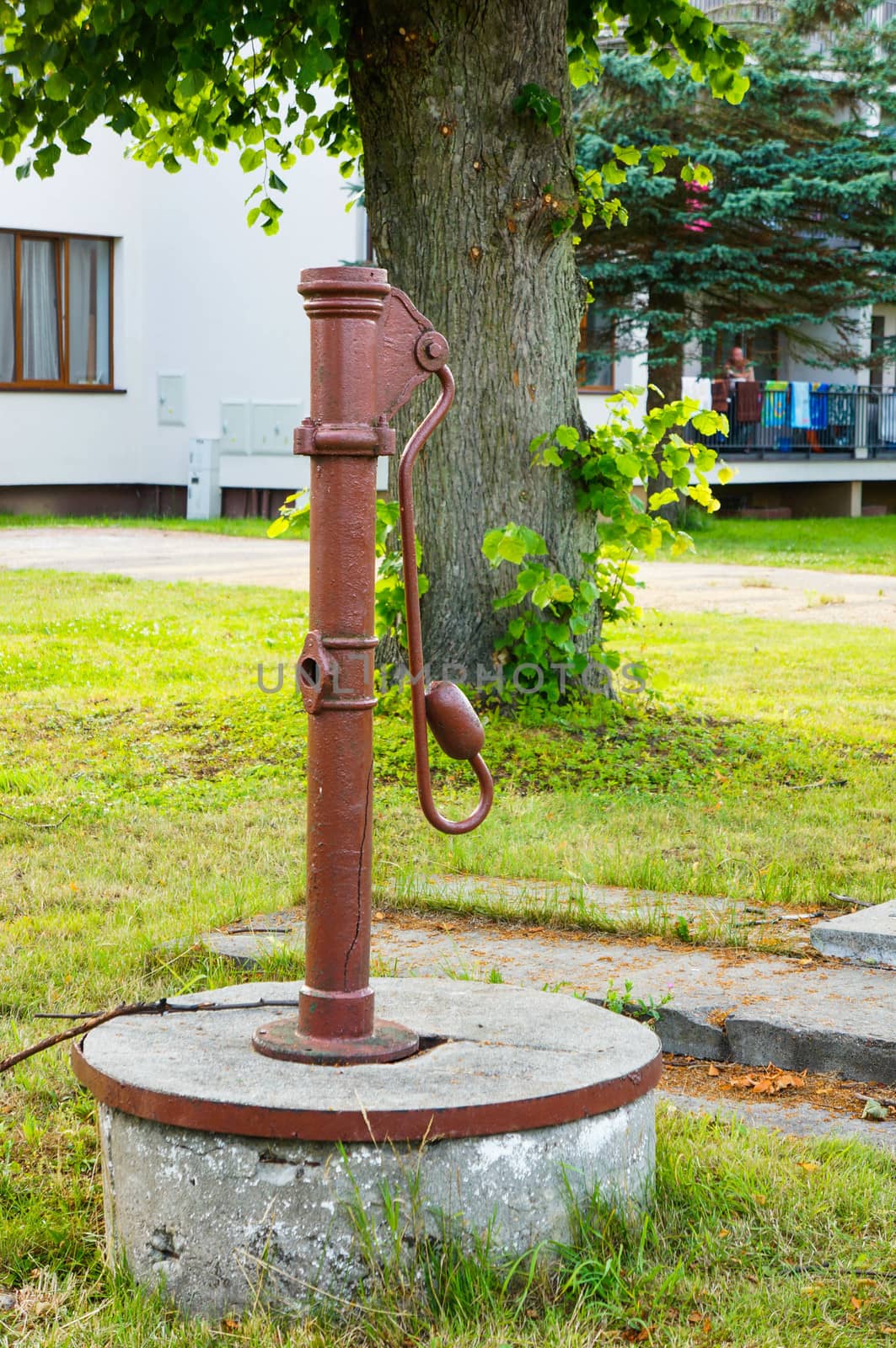Metal water pump on green grass