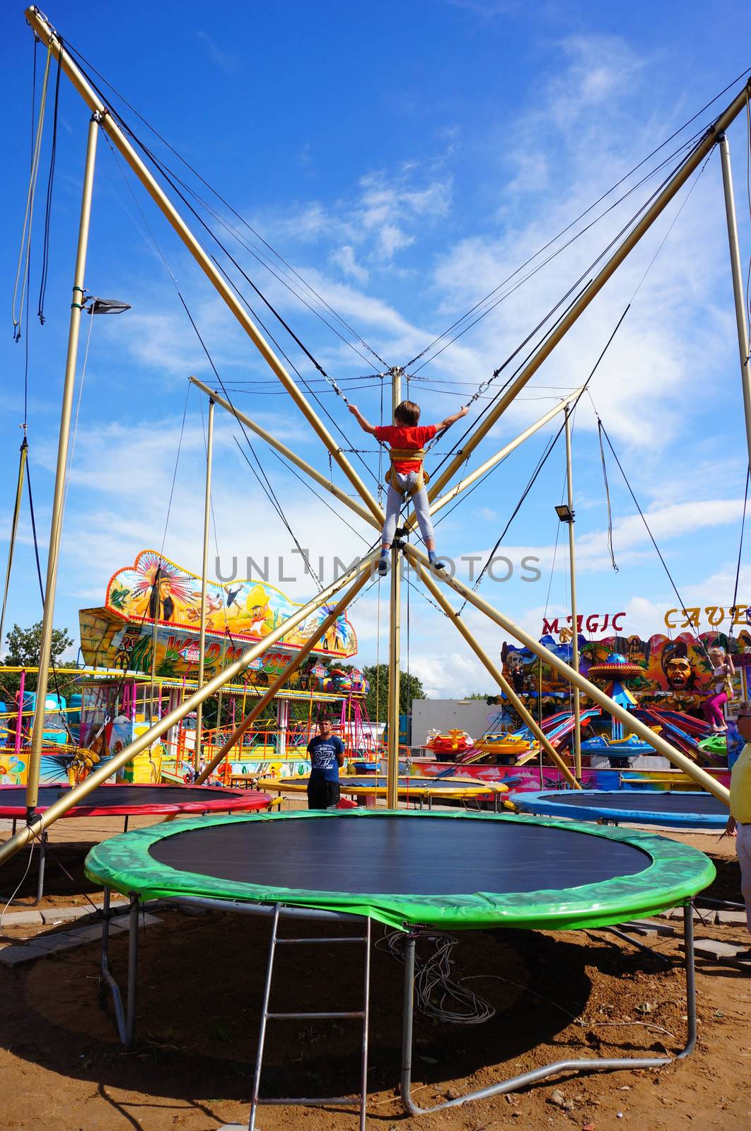 USTRONIE MORSKIE, POLAND - JULY 20, 2015: Tied child jumping on a trampolin at a fair