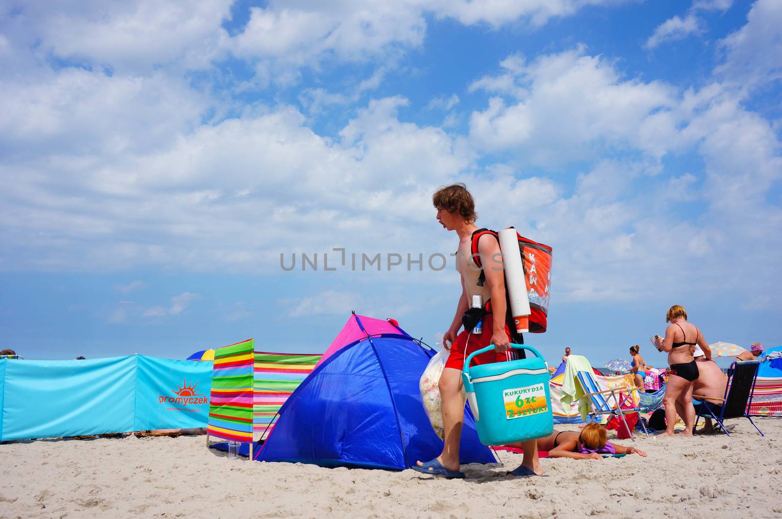 SIANOZETY, POLAND - JULY 22, 2015: Man carrying food and walking on a beach