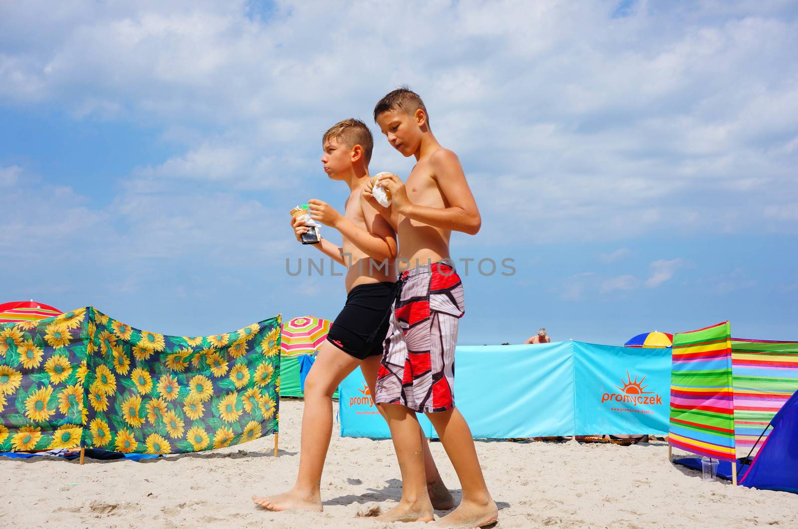 SIANOZETY, POLAND - JULY 22, 2015: Two boys walking on sand at a beach 