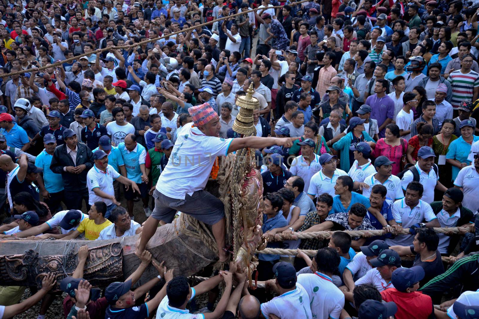NEPAL, Patan: Hindus and Buddhists gather around the chariot of Rato Machhindranath as it is pulled along a river in Patan, Lalitpur, Nepal, on September 23, 2015. 