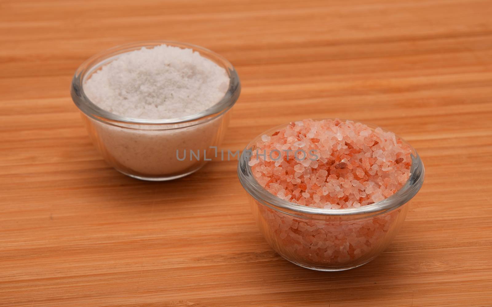 Choose your salt - Himalayan or rock salt (angle view) on wooden bamboo background