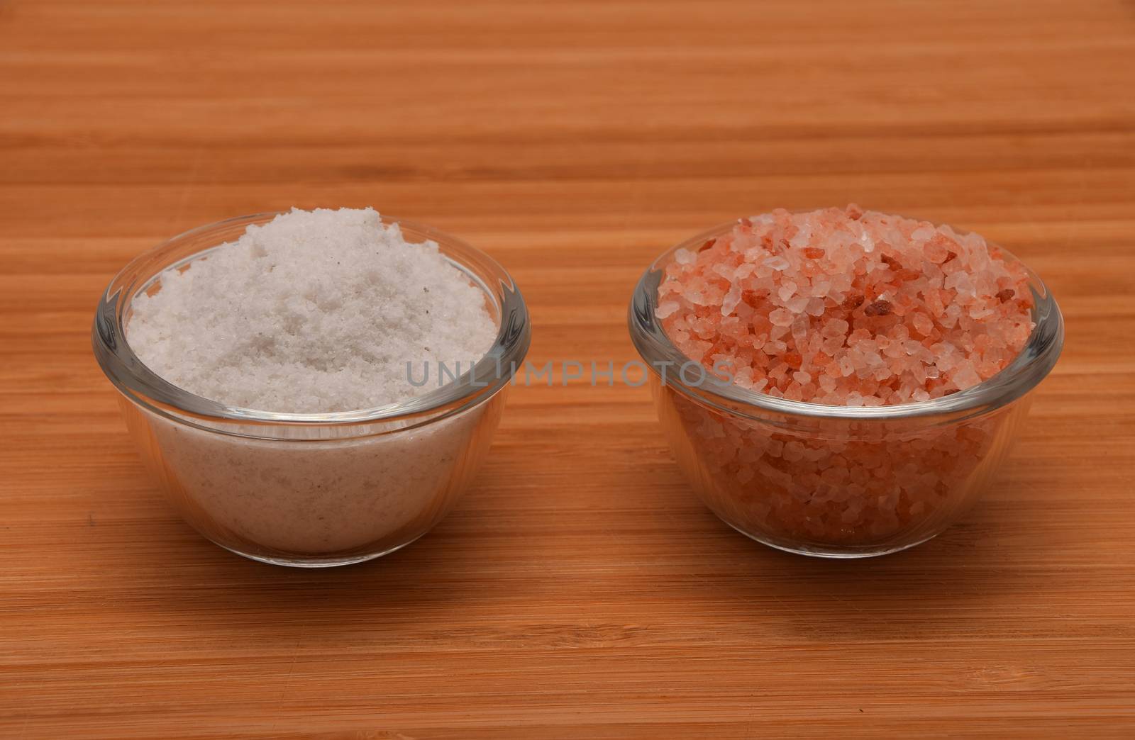 Choose your salt - Himalayan or rock salt (side view) on wooden bamboo background