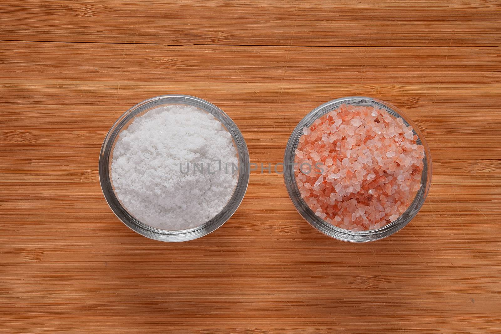Choose your salt - Himalayan or rock salt (top view, point of view) on wooden bamboo background