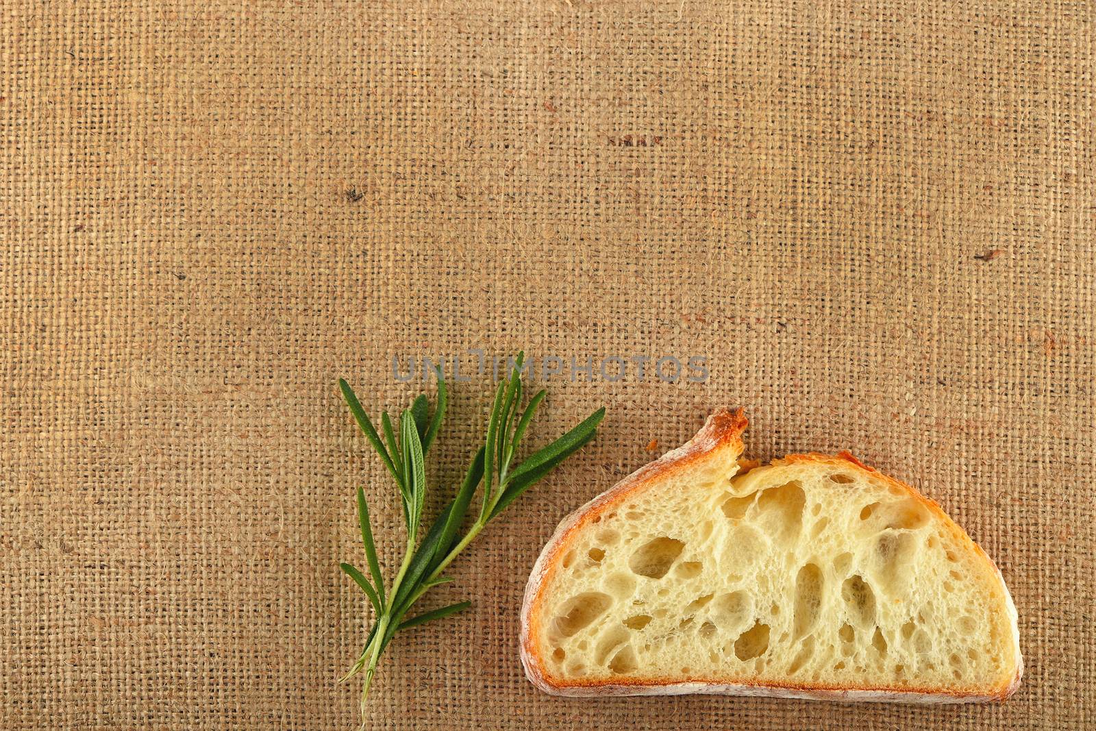 Canvas with rosemary leaves and slice of wheat bread by BreakingTheWalls